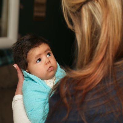 postpartum doula holding newborn