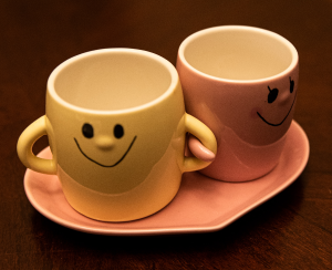 2 smiling cups linking arms