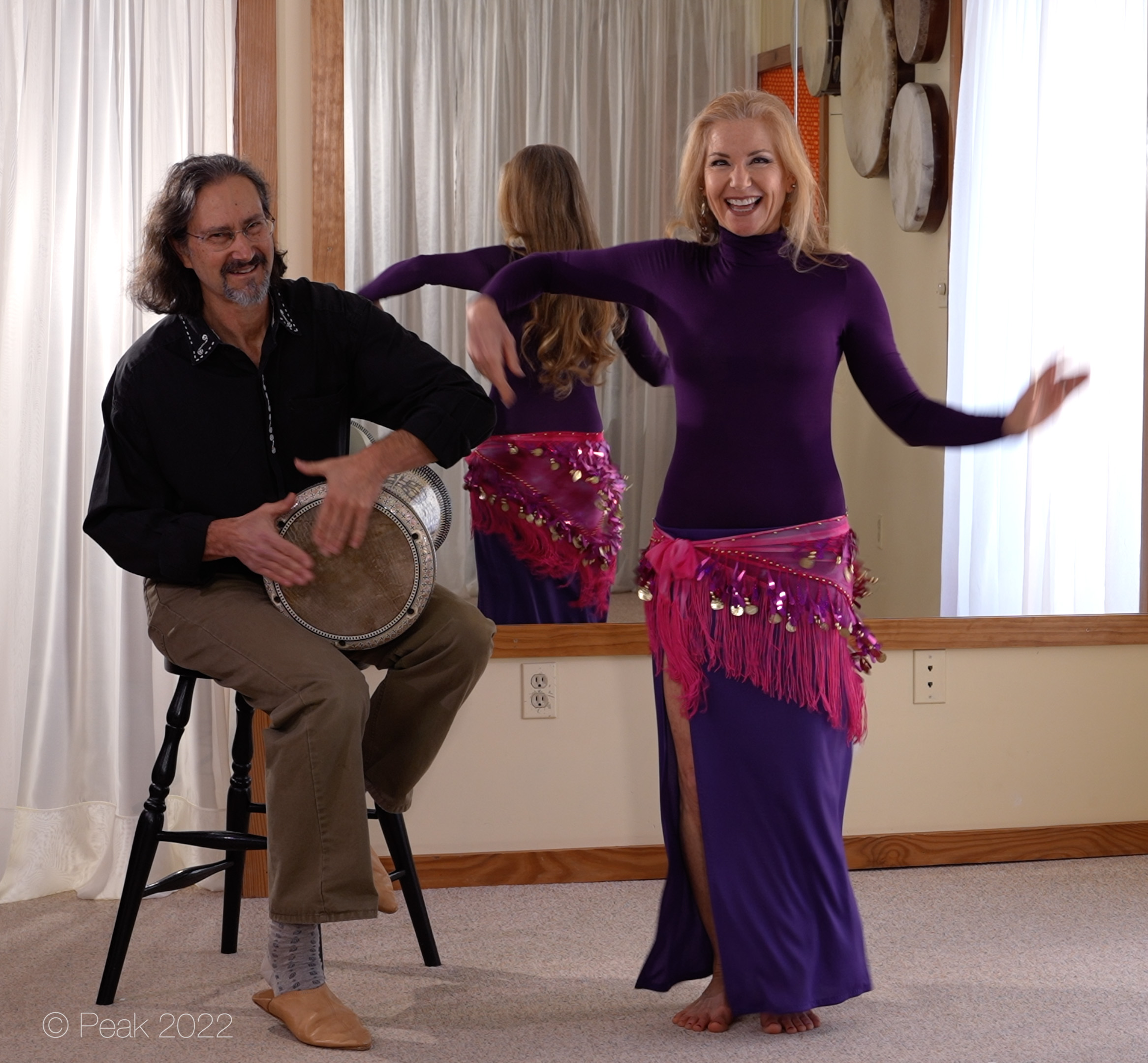 Jensuya and Bob smiling and drumming and belly dancing in studio