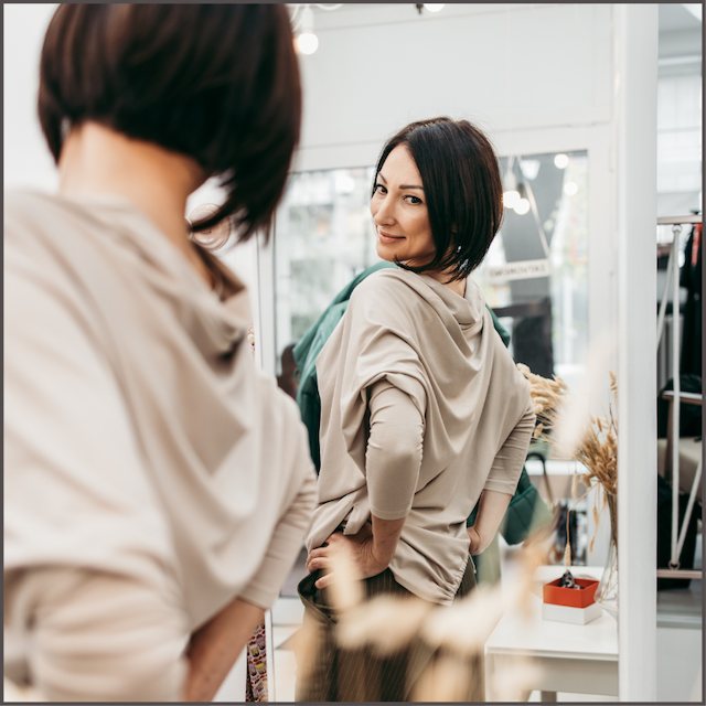 woman looking at herself in store mirror