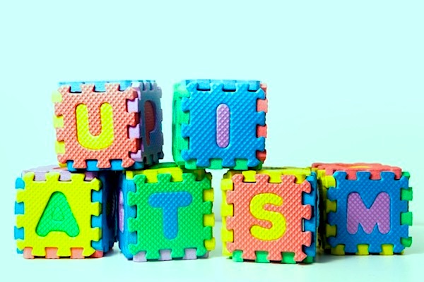 Six colourful building blocks with letters on them arranged to spell the word &#39;Autism&#39;