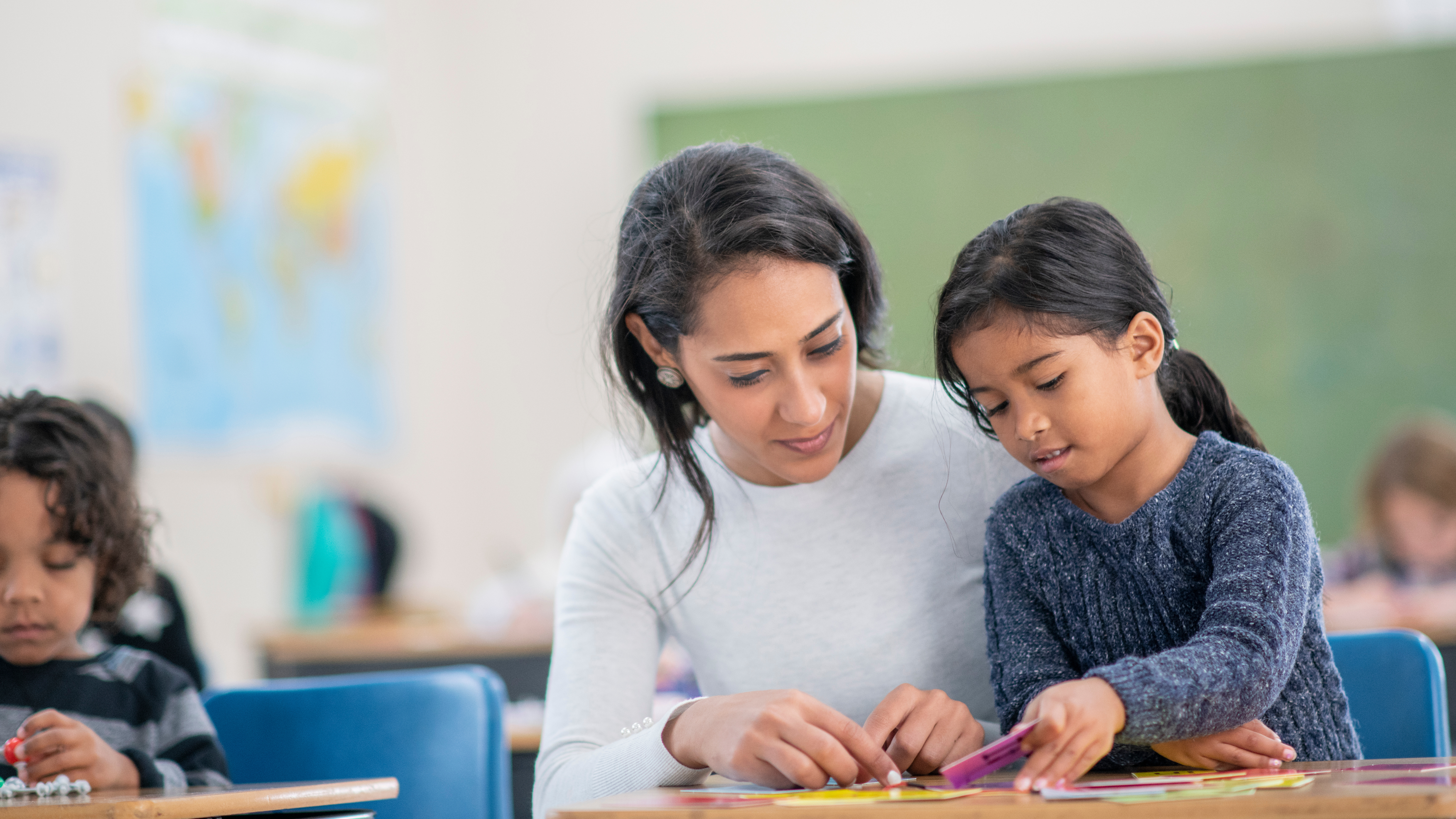 teacher helping student with hands on work