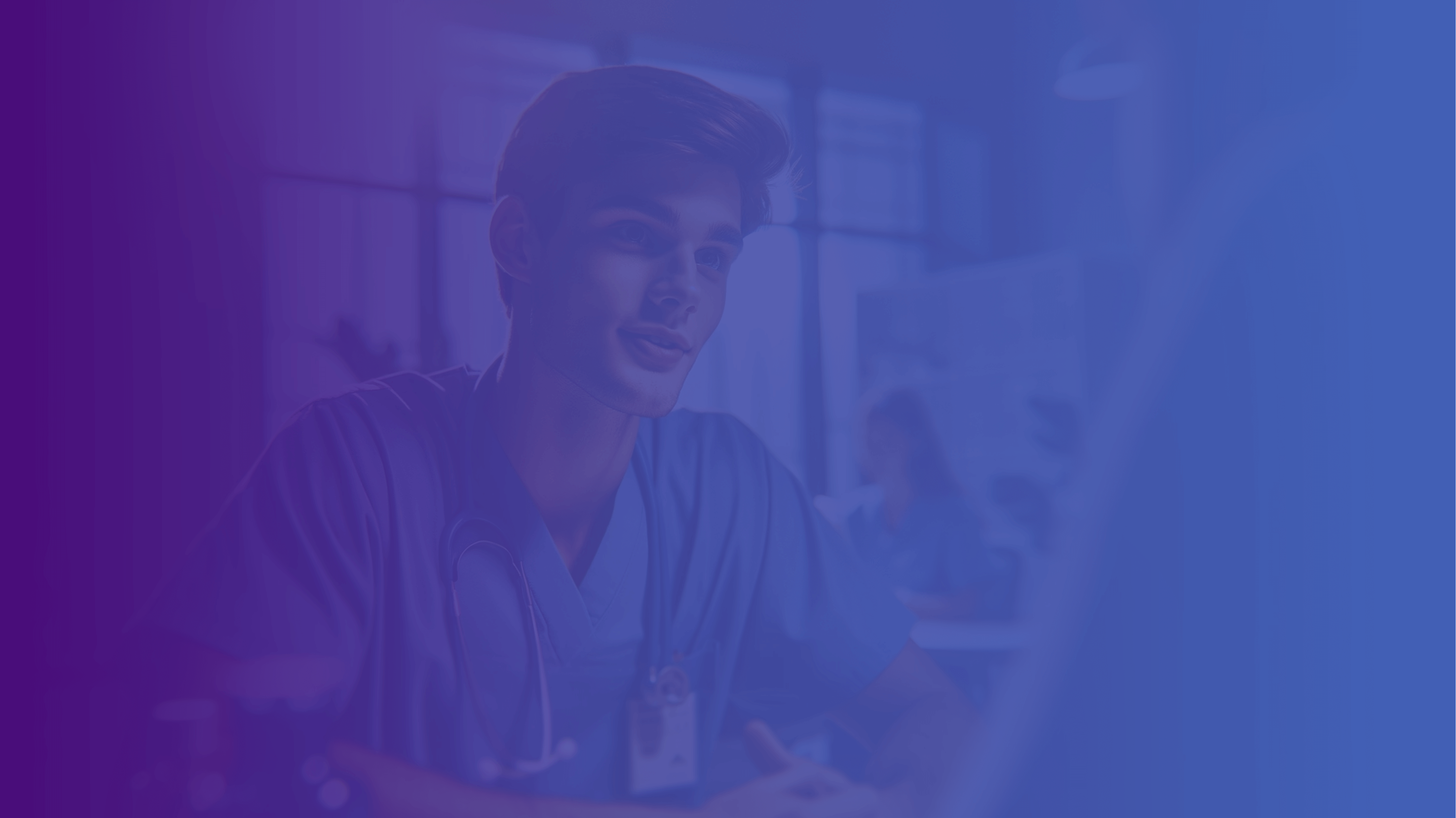 A confident young male NHS doctor in blue scrubs, with a stethoscope around his neck, is engaging with a colleague or patient in a sunlit, modern medical office. The warm lighting and focused interaction suggest a professional and caring healthcare environment.