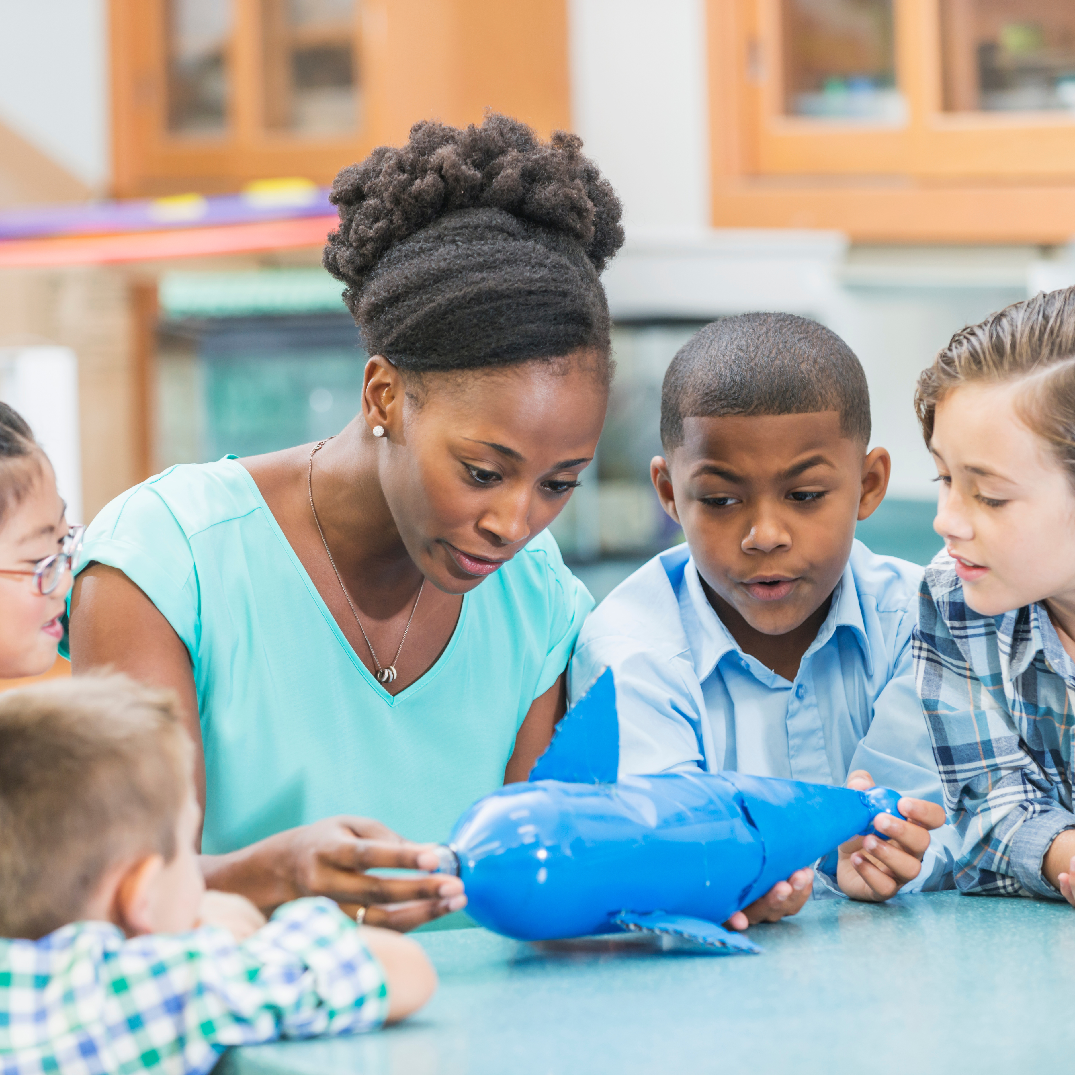 teacher working with students using a science model