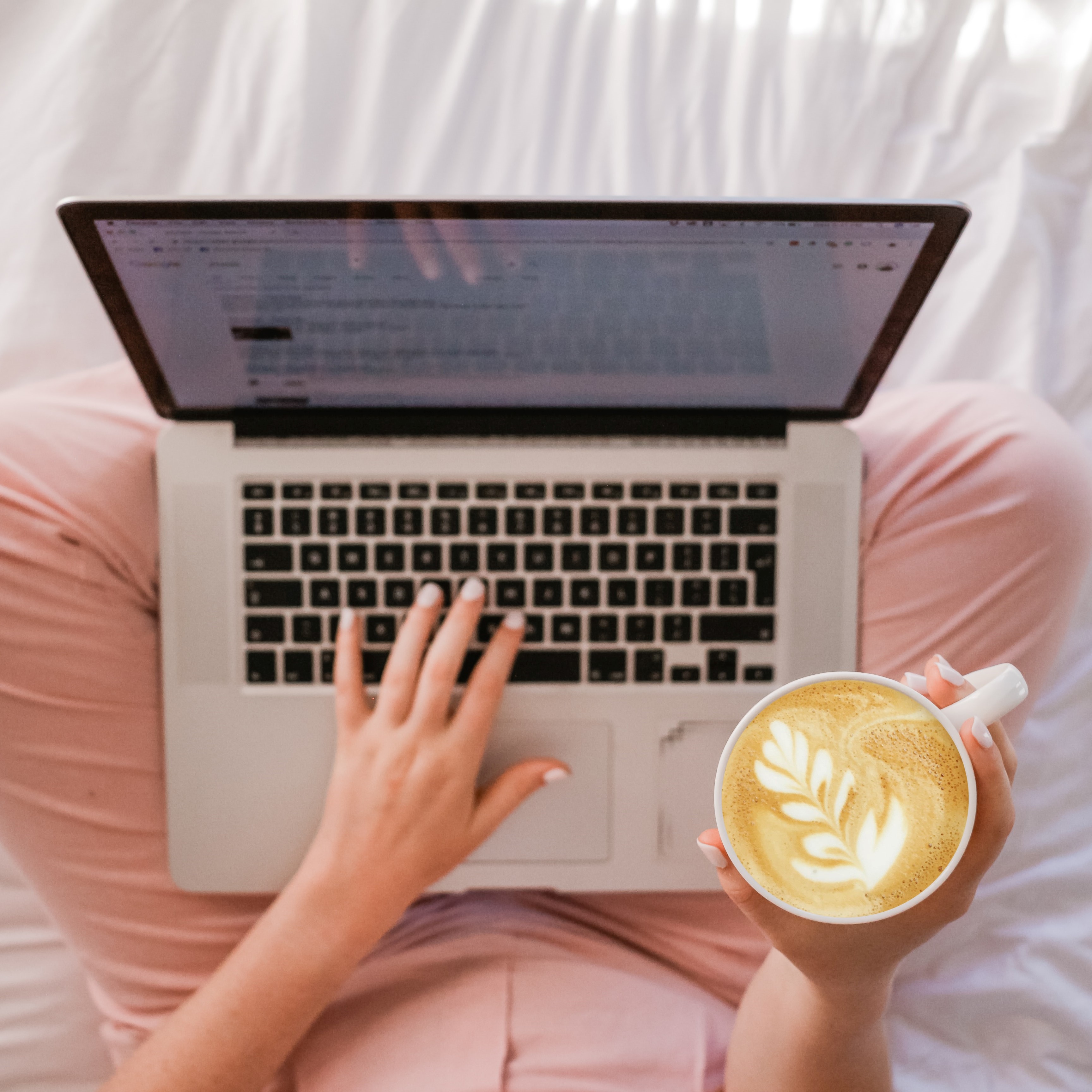 A woman with coffee working on her laptop