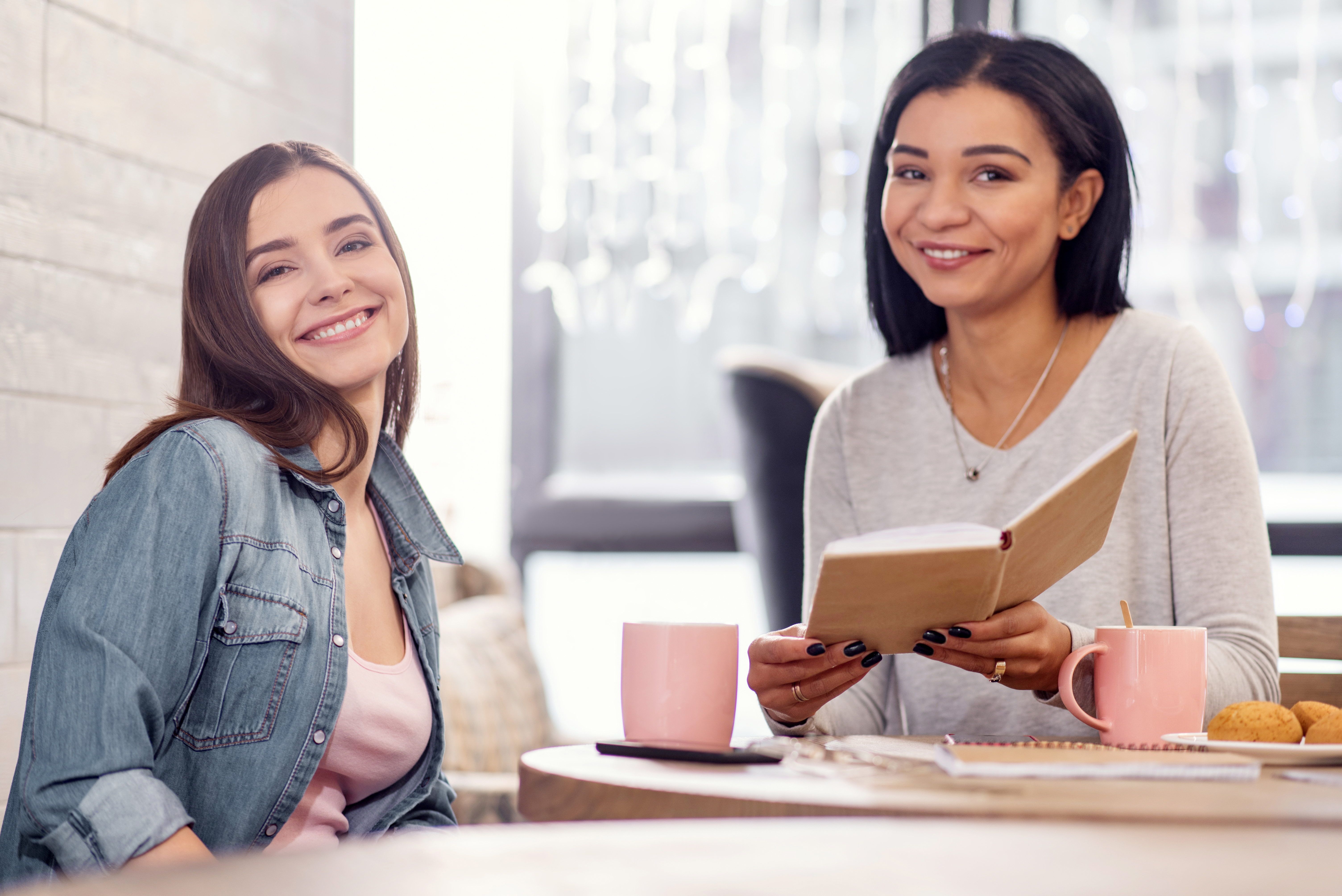 Two women in office smiling at the camera