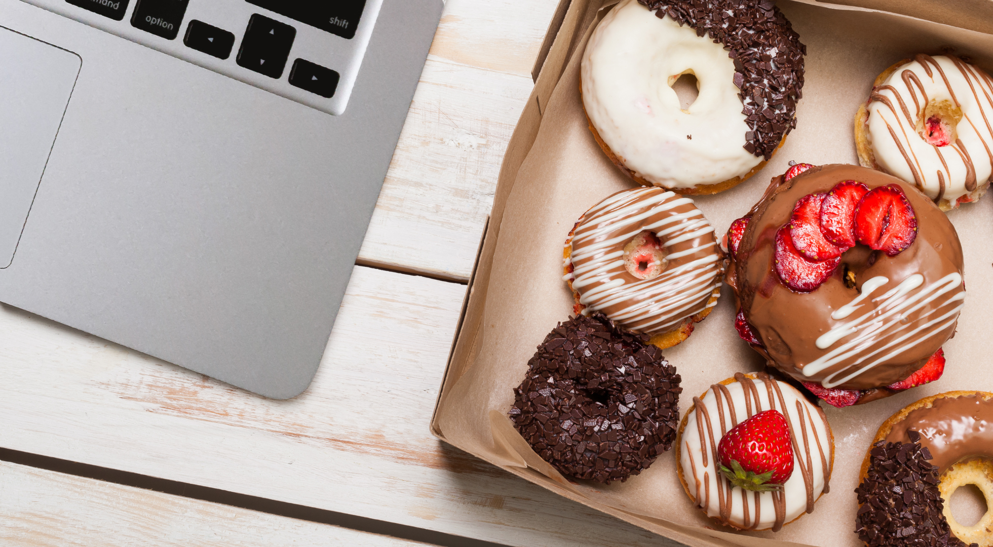 Image of donuts next to a computer used to showcase how the Sugar Coin Academy is a business academy for bakers and sweet treat makers.