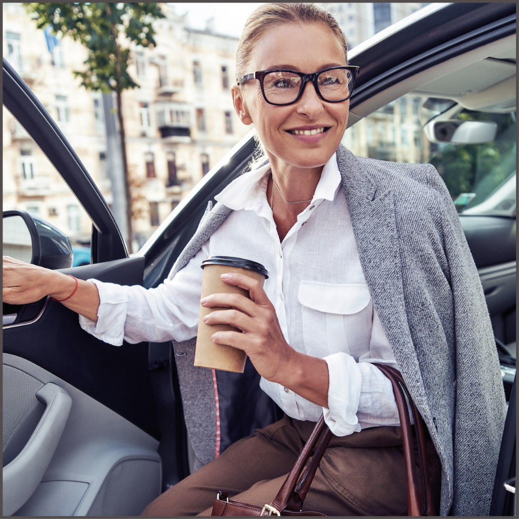 Beautifully dressed mature woman getting out of car.