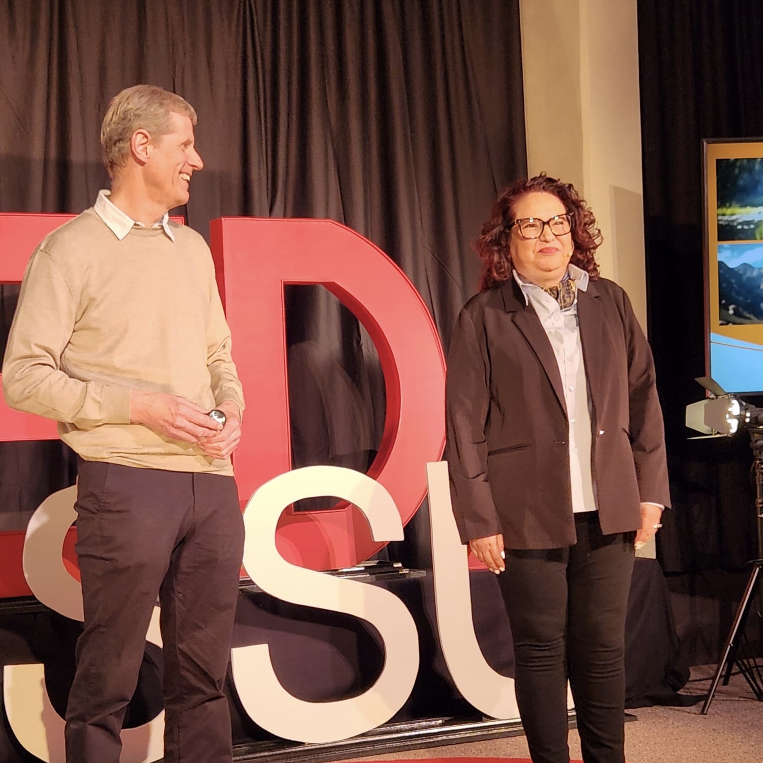 Image of Colin Corby and Ana Smith giving their TEDx talk in March 2023.