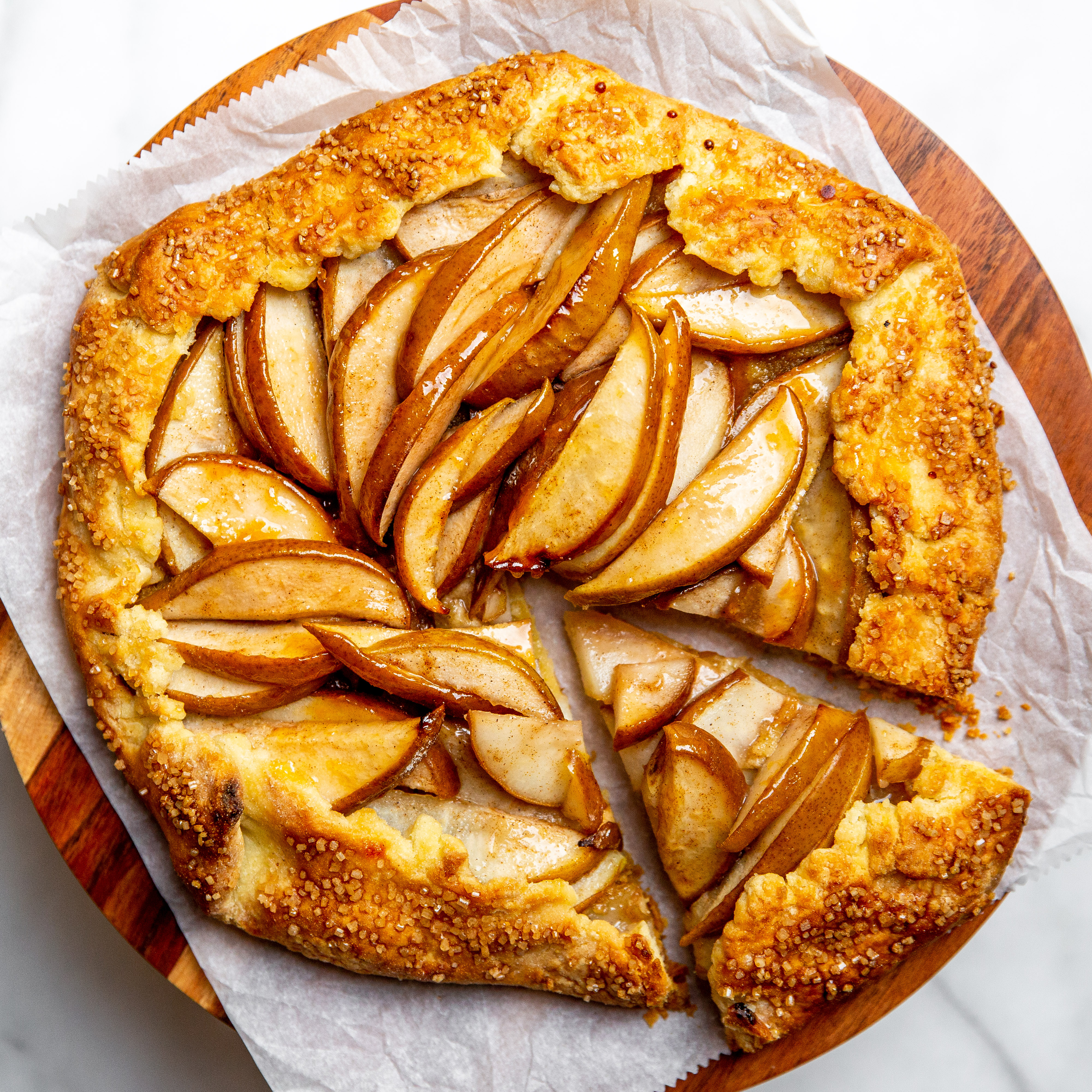 Gluten free pear and almond galette on a wooden serving board.