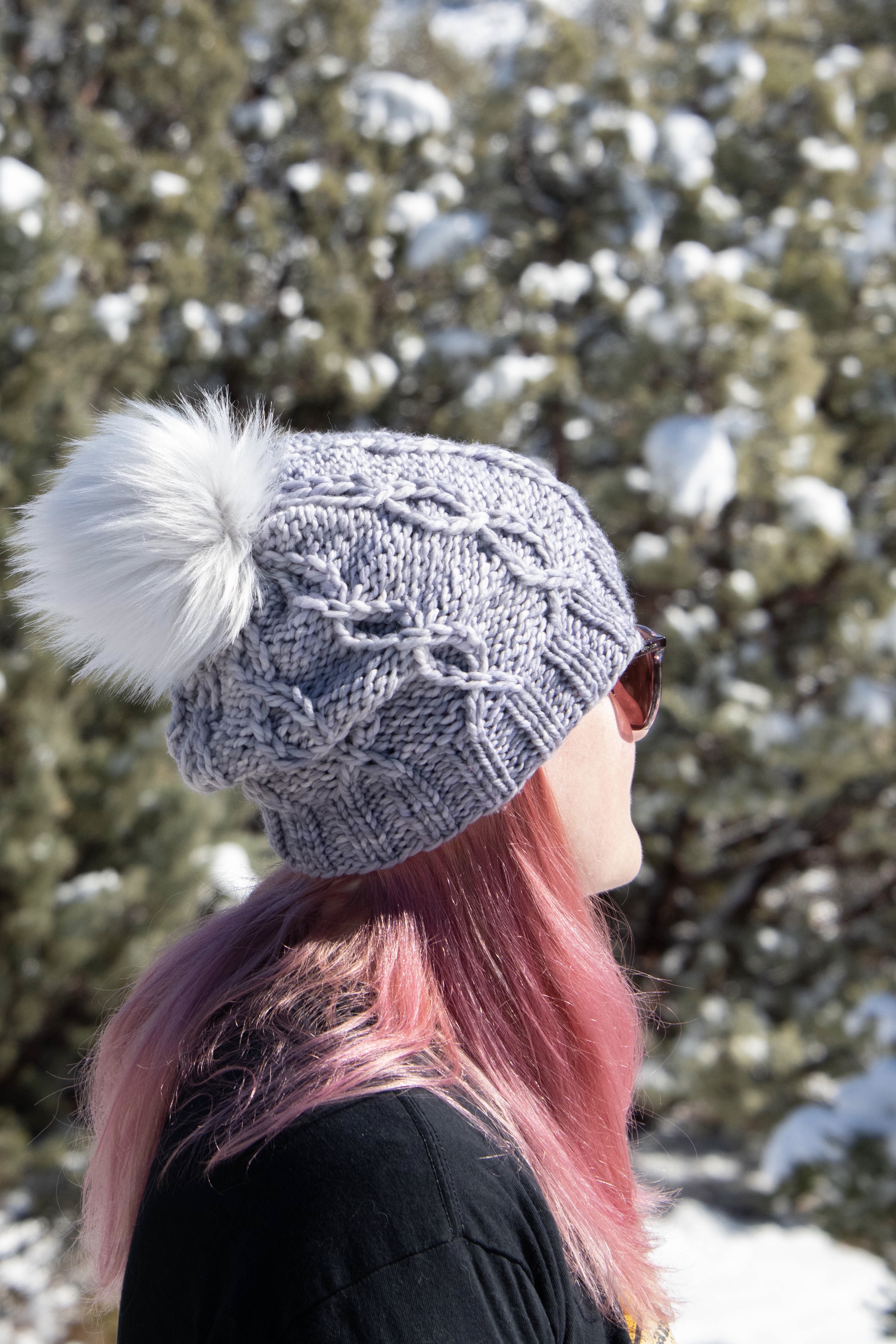 girl wearing cabled knit hat with pom