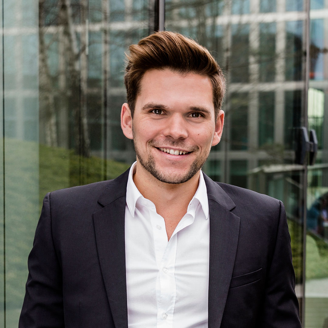 A picture showing a portrait of Philipp Brunenberg in front of a glass window.