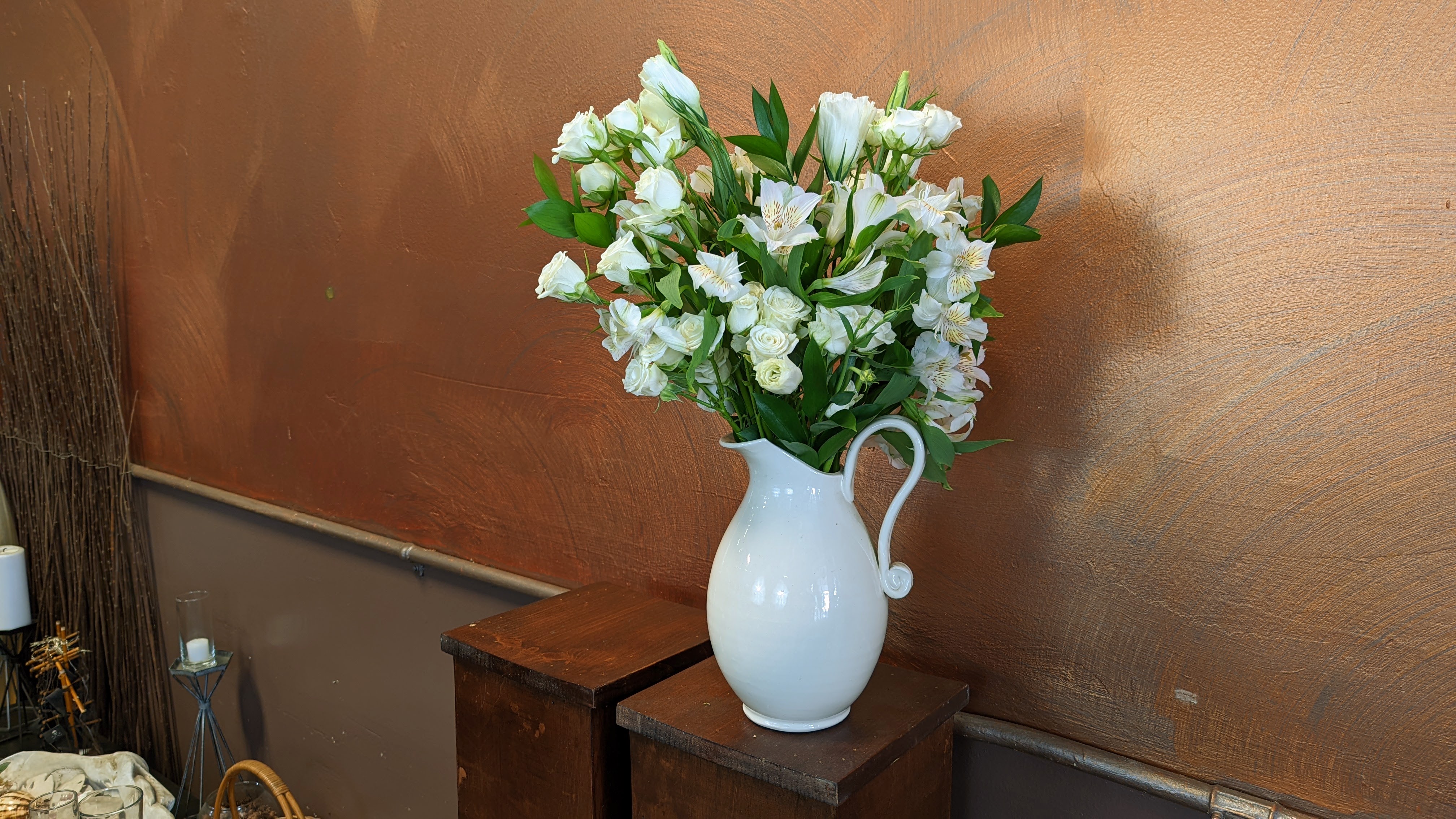 White pitcher with white flowers inside