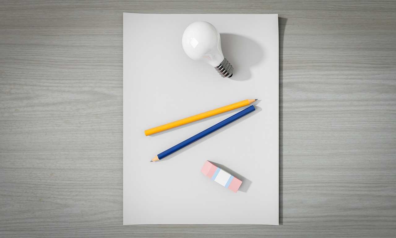 Light bulb and pencils on a blank sheet of paper