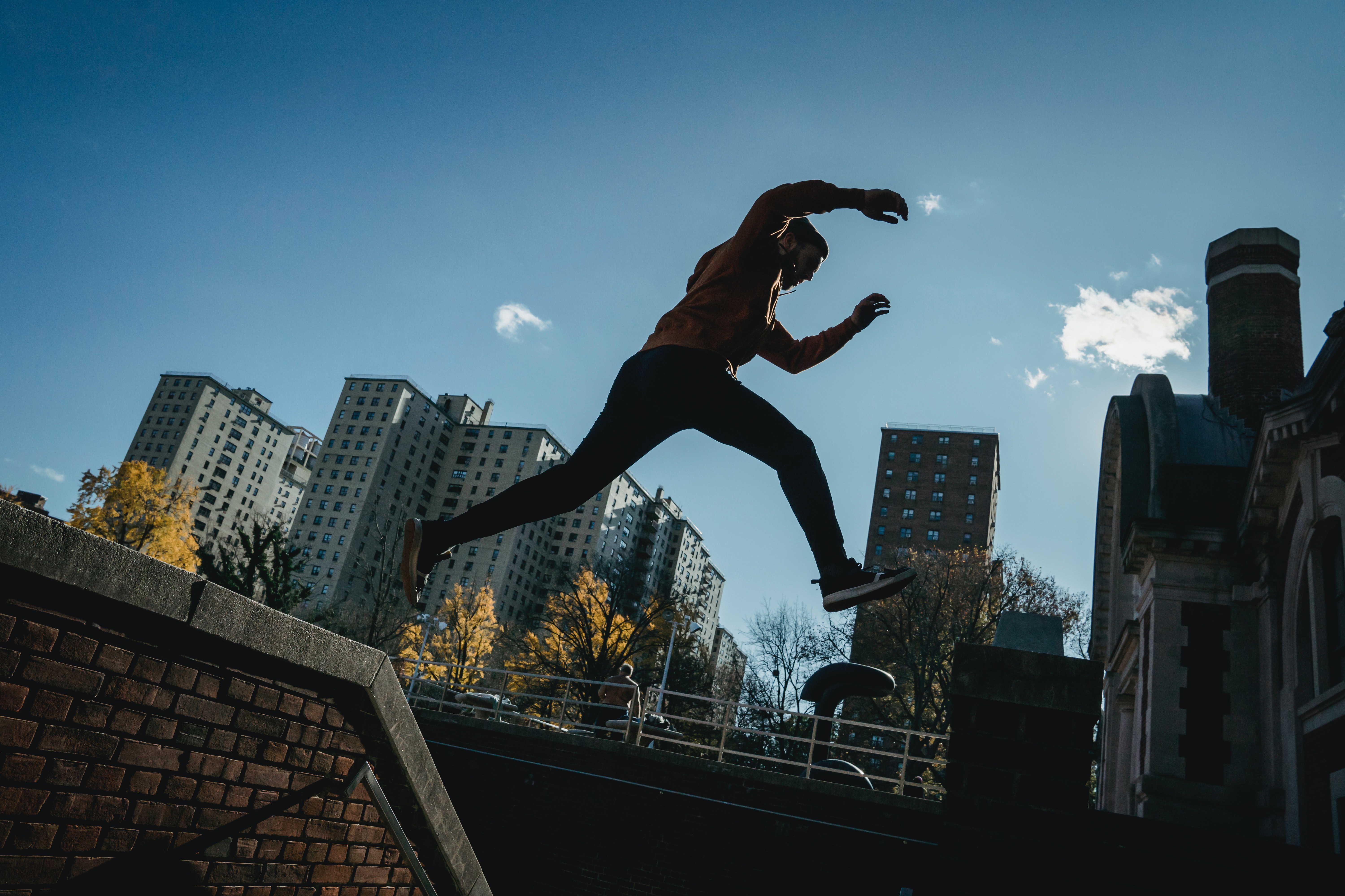 Man in an urban setting leaps from one wall to another.
