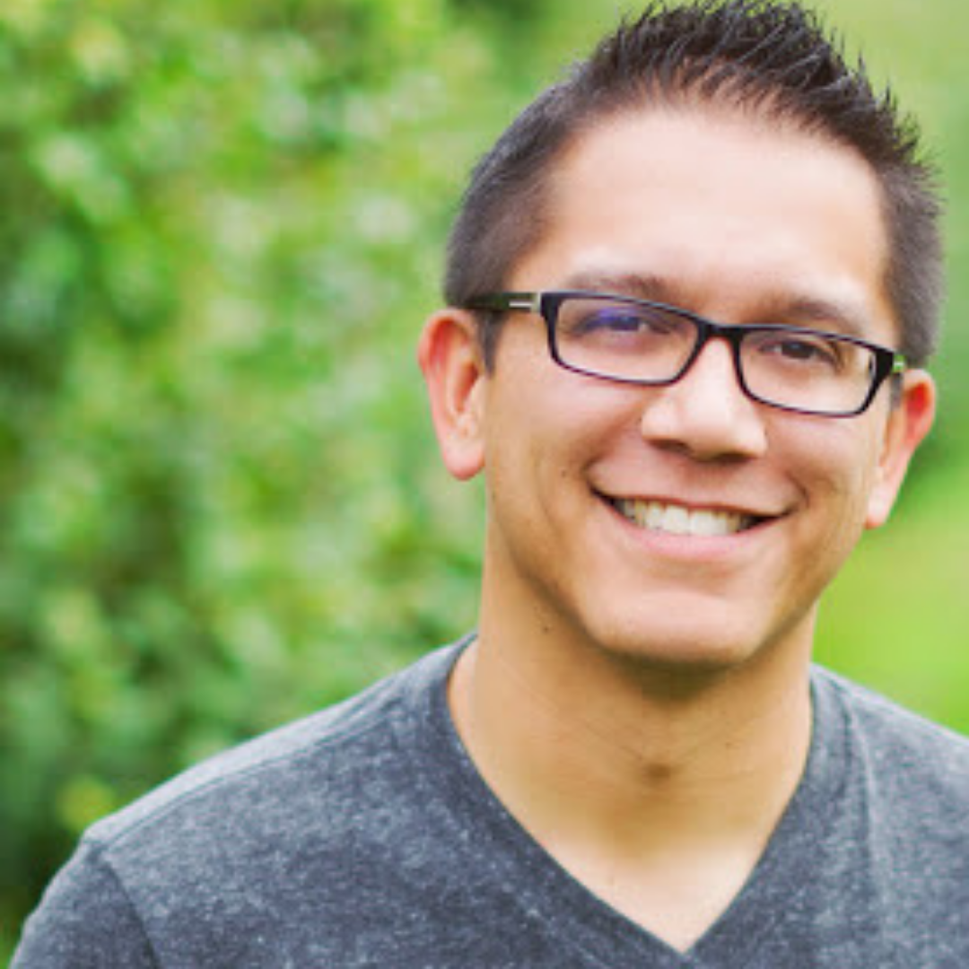 Henry Zonio with glasses in front of greenery