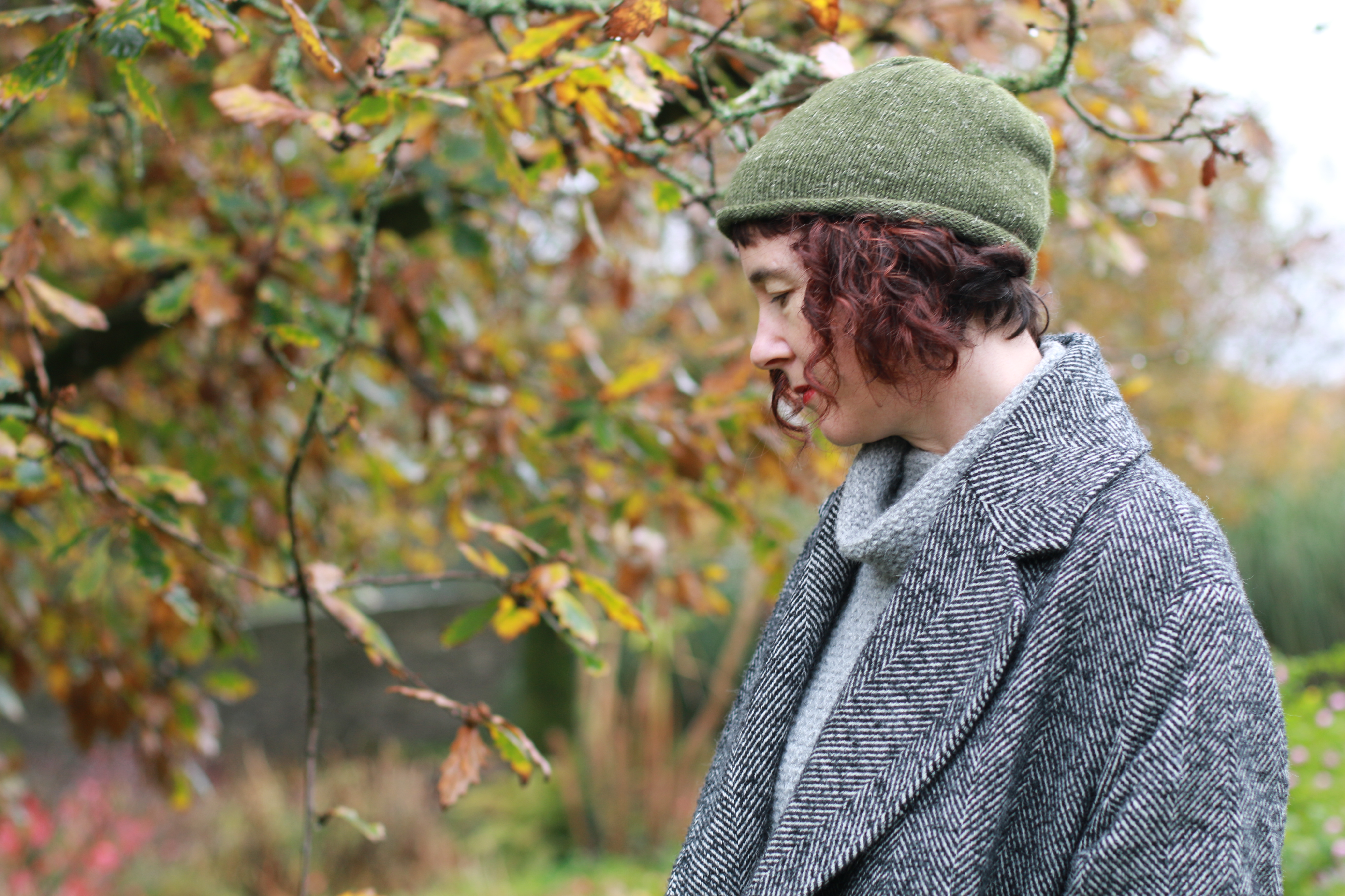 woman wearing green knitted hat in front of tree