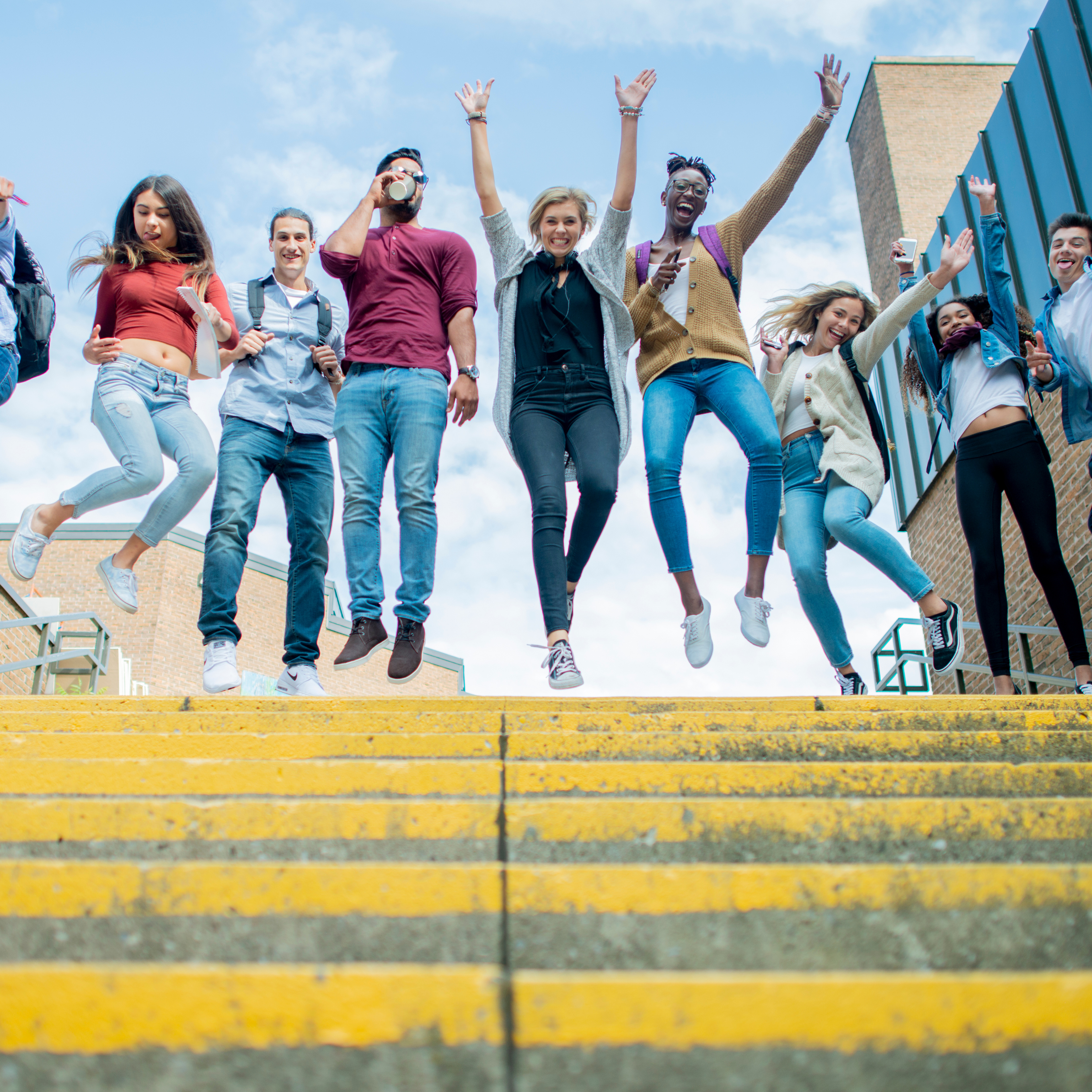 happy people jumping at the top of the stairs