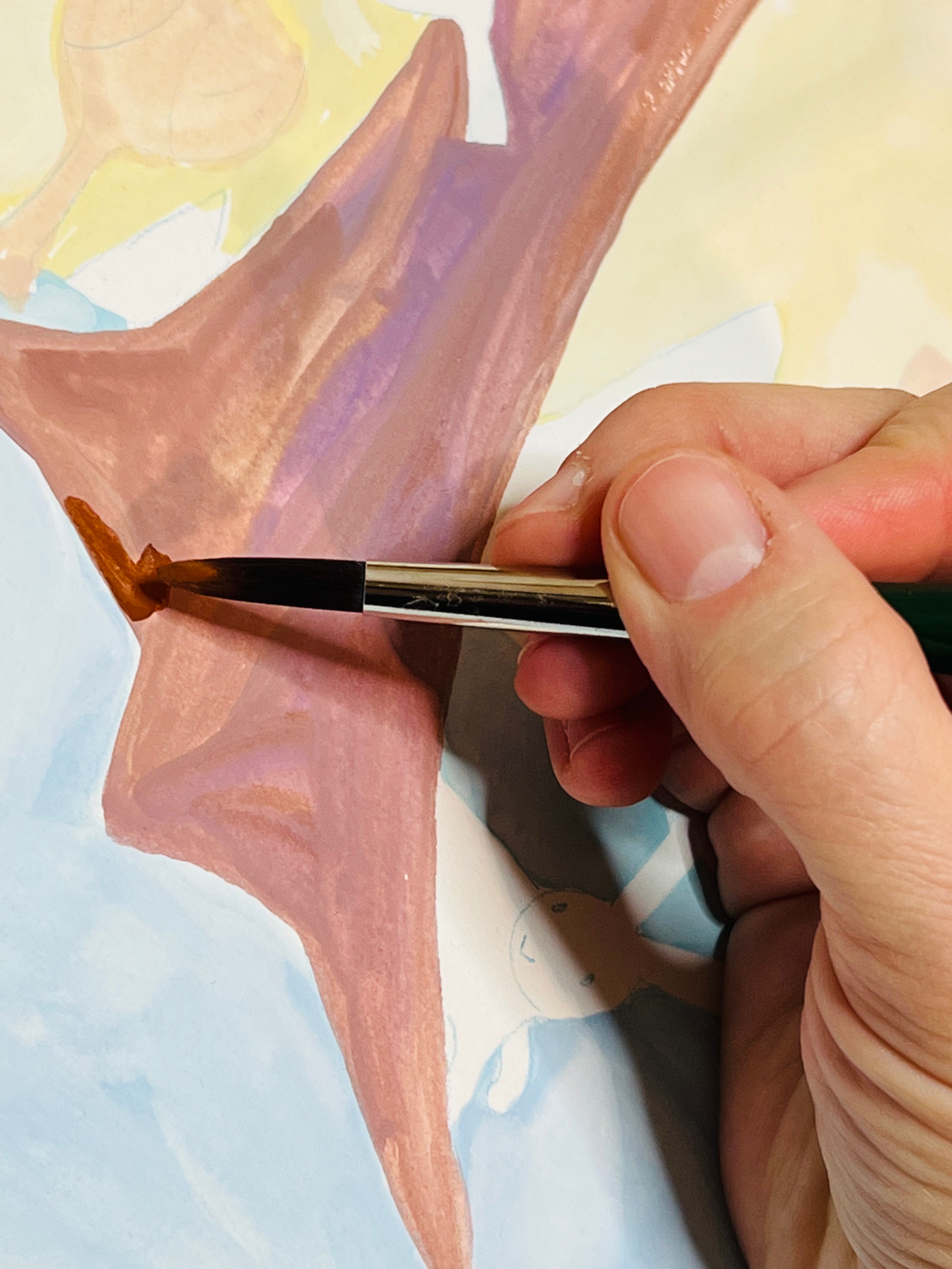 hand holding a small paintbrush with brown paint, painting a close up of a tree trunk