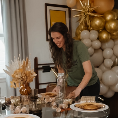 Katie setting up a tablescape, balloons in the background