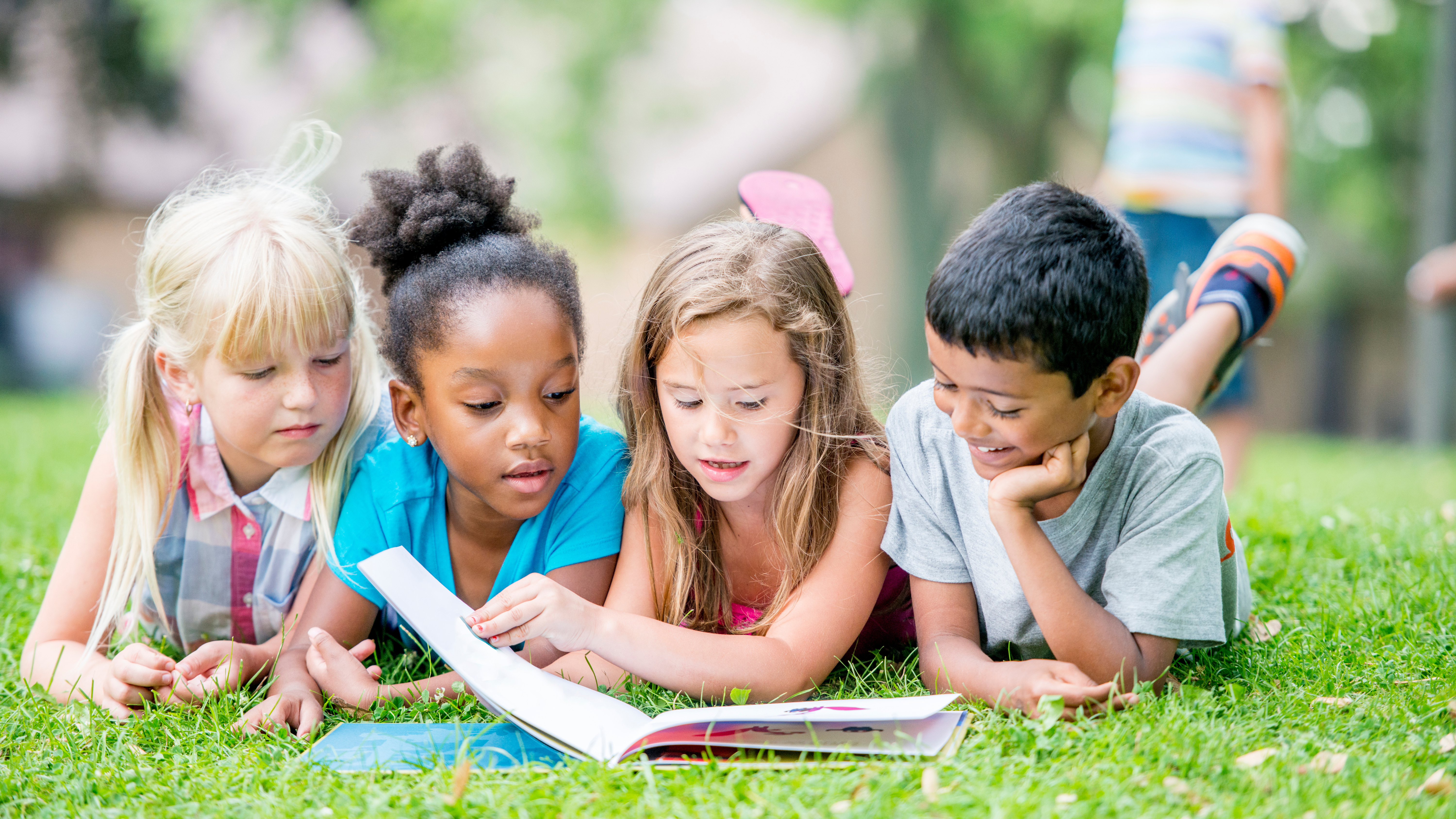 kids reading in the grass