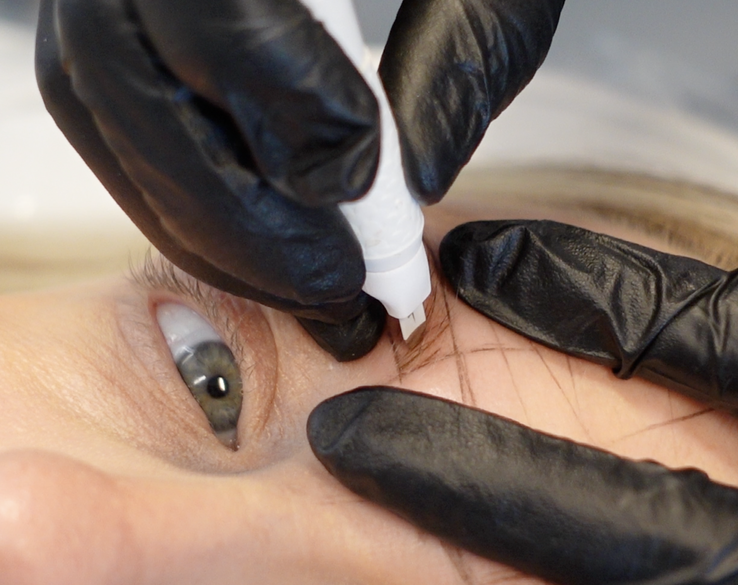 Microblade implanting pigment during Microblading session