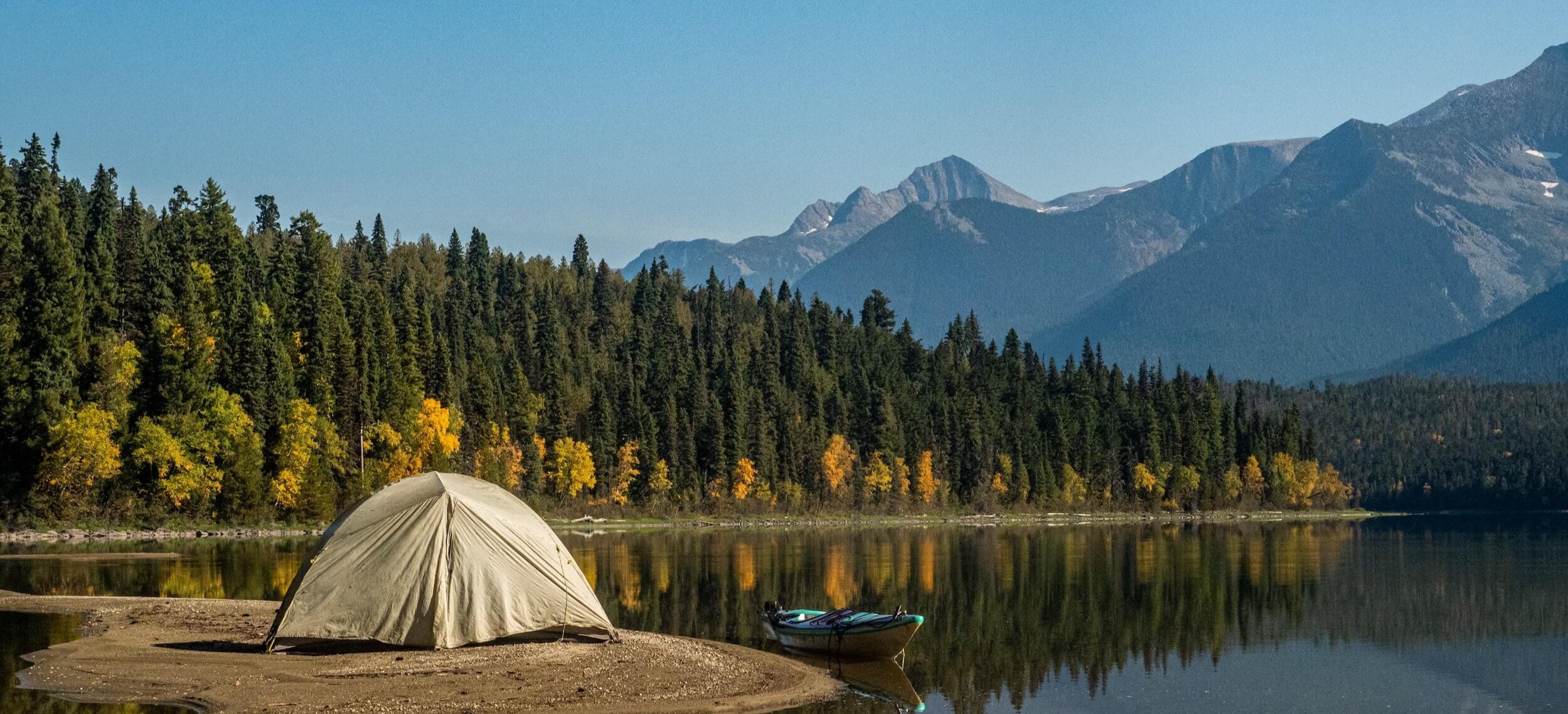 Camping tent in mountainous nature by a lake