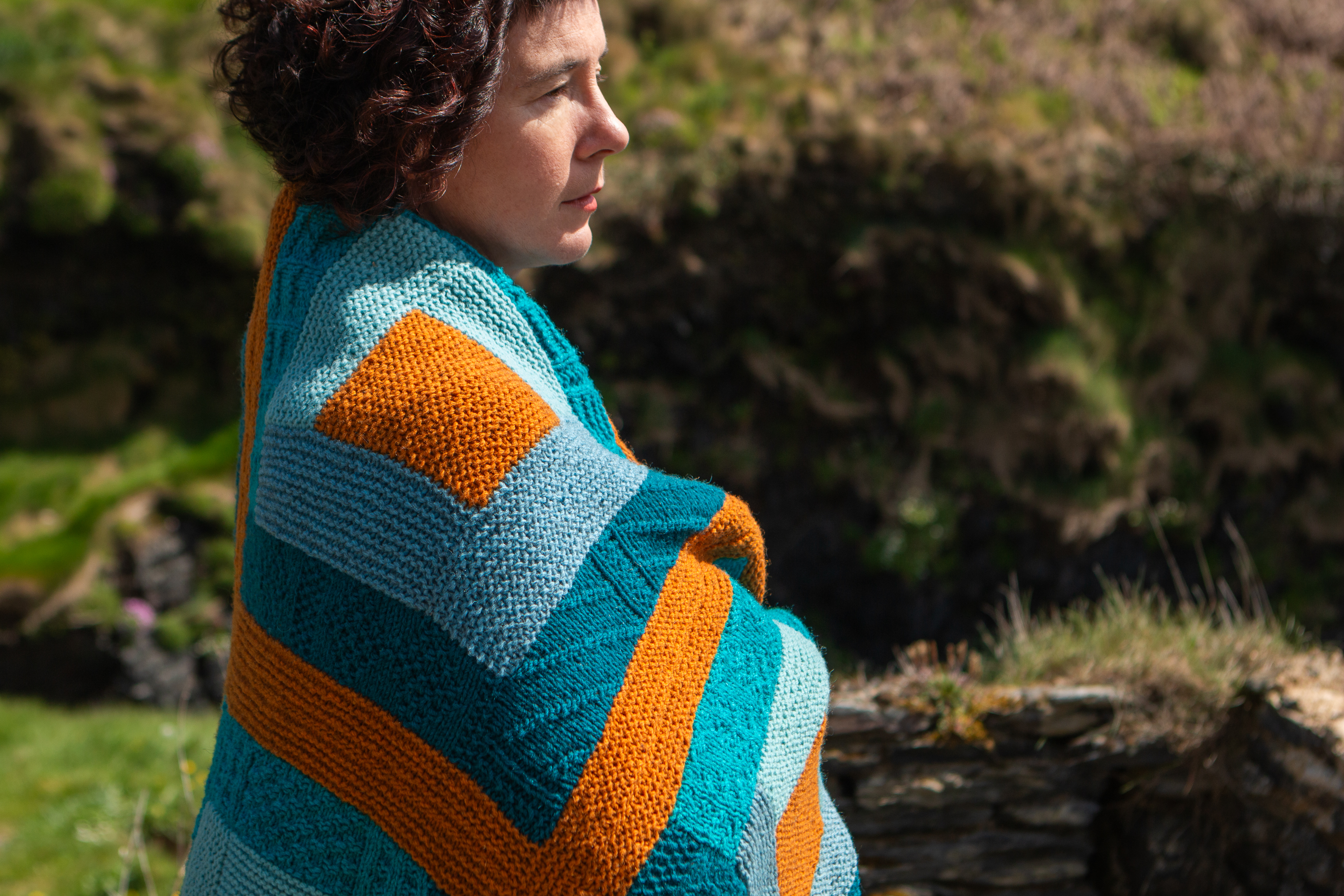 Woman wrapped in a colourful blanket.