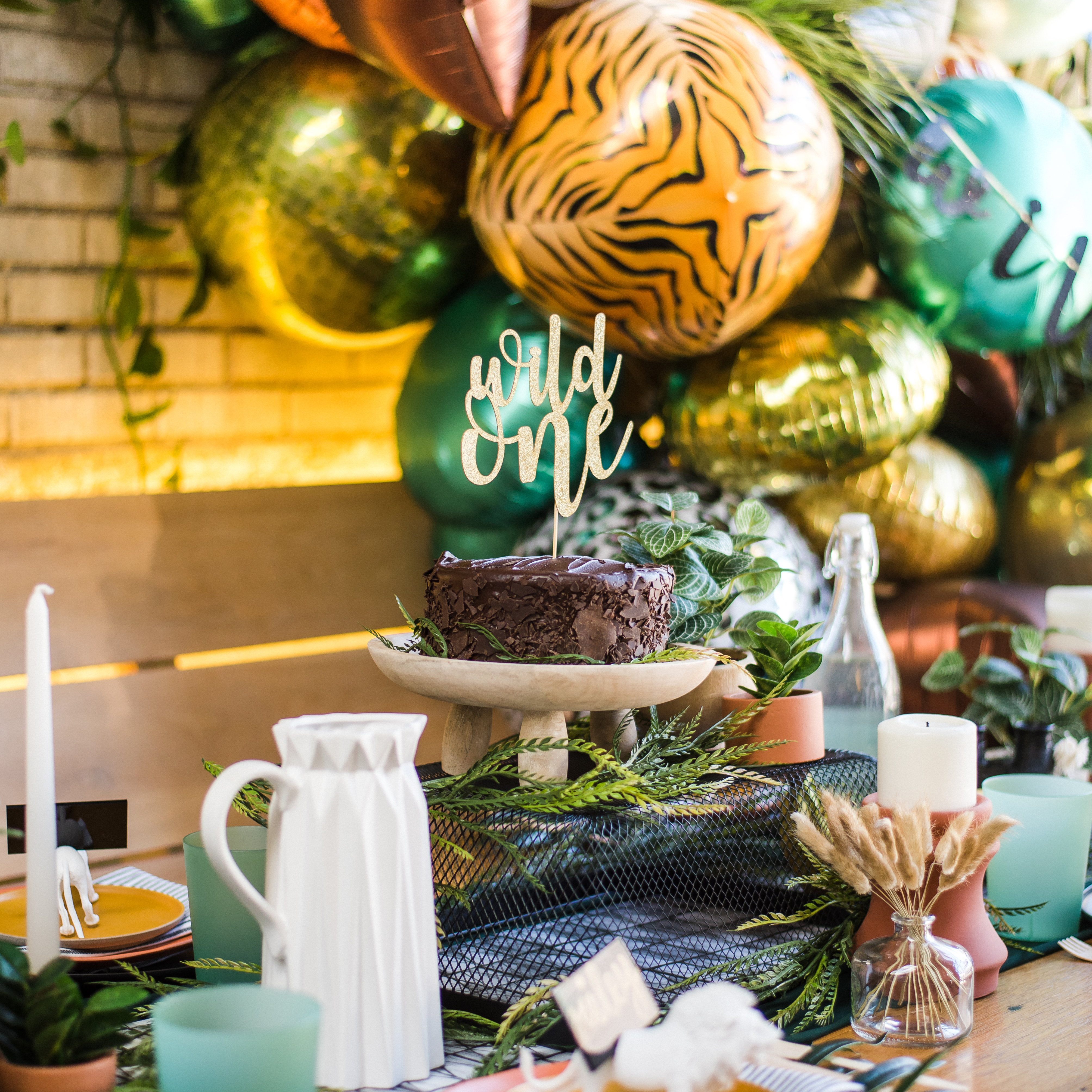 Wild One birthday party with balloons, tablescape, and cake
