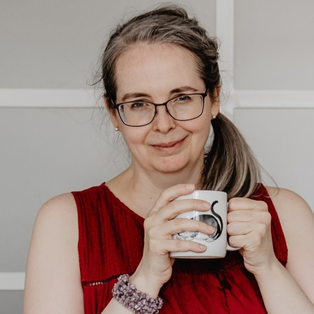 Canadian woman smiling, holding a cup of tea in her hands