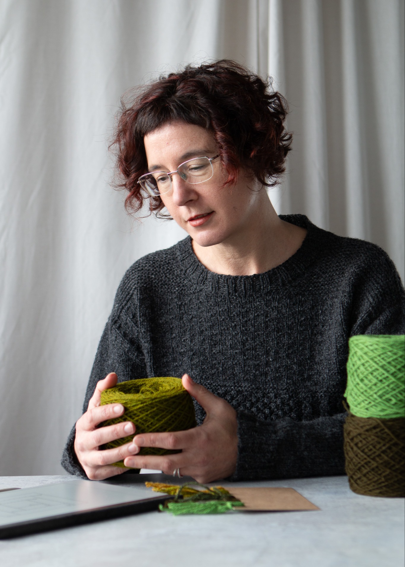 Carol Feller holding a cake of green yarn