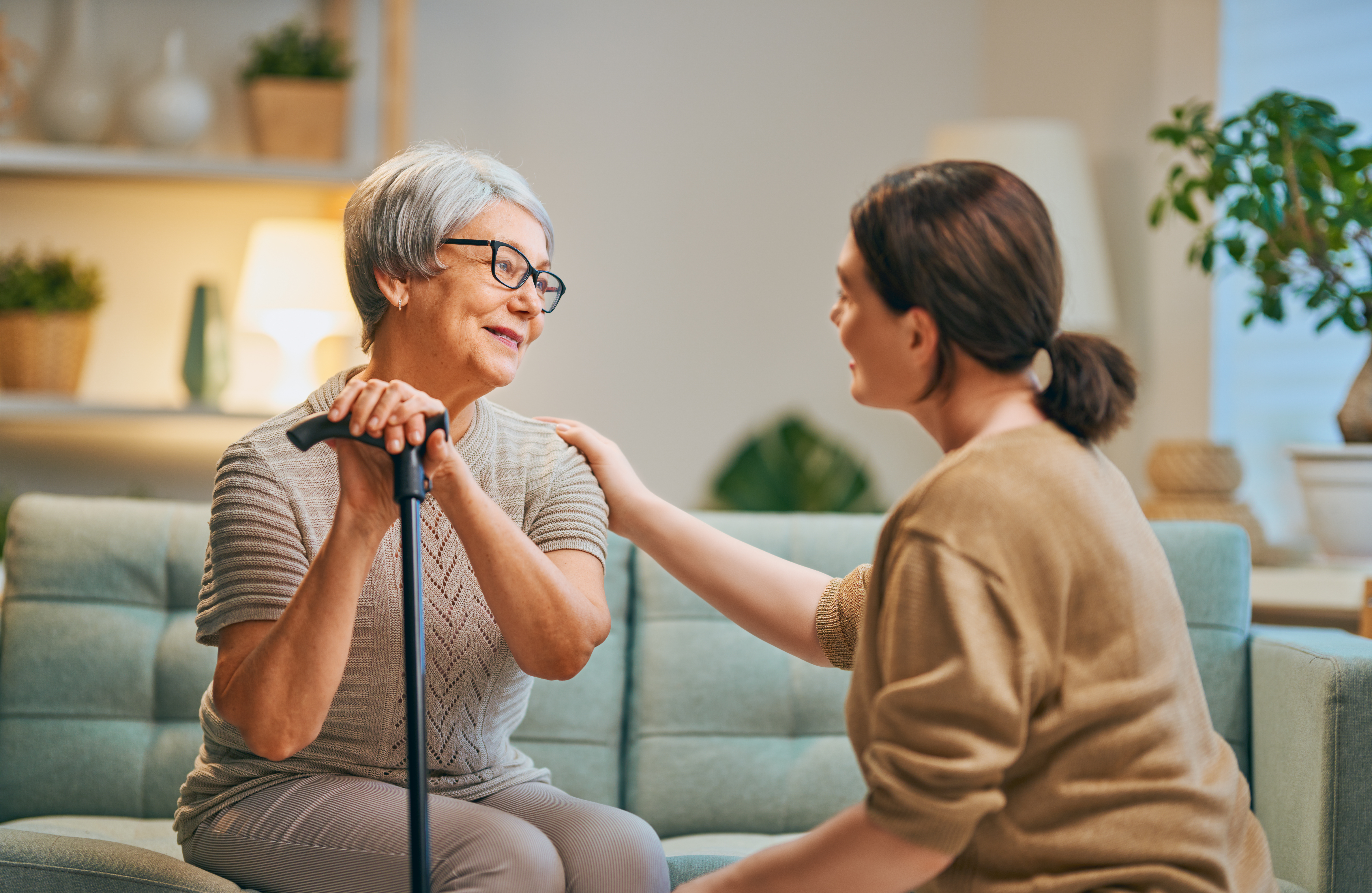 Female caregiver with older woman looking with care at each other