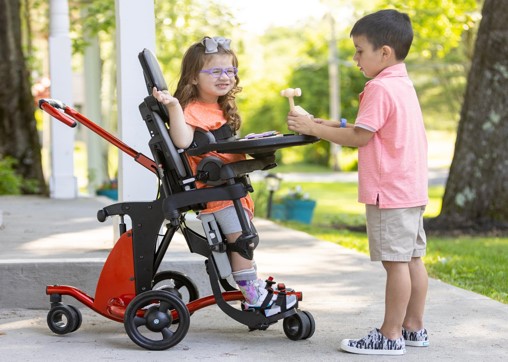 child on a stander playing with another child