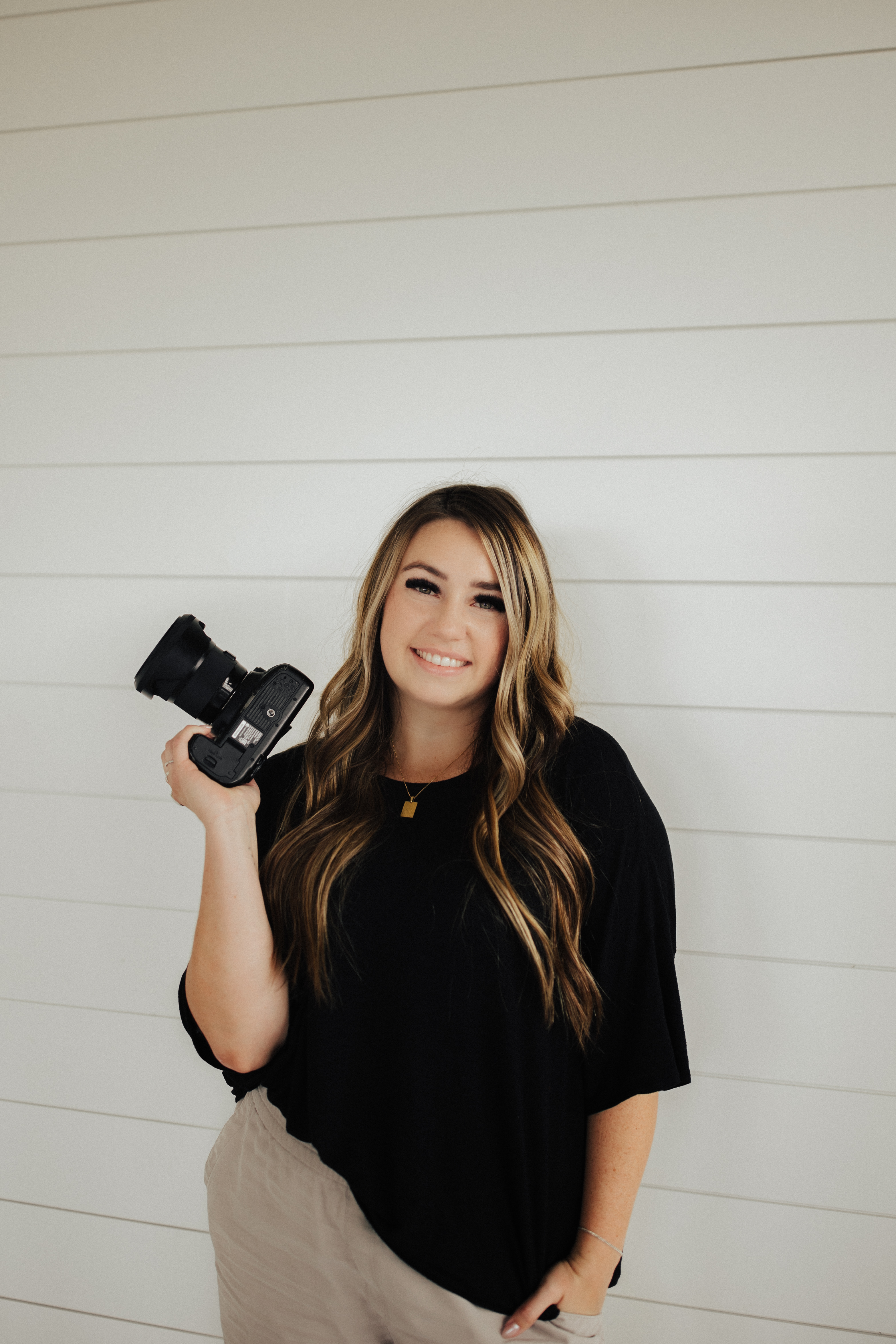 photographer holding a camera smiling