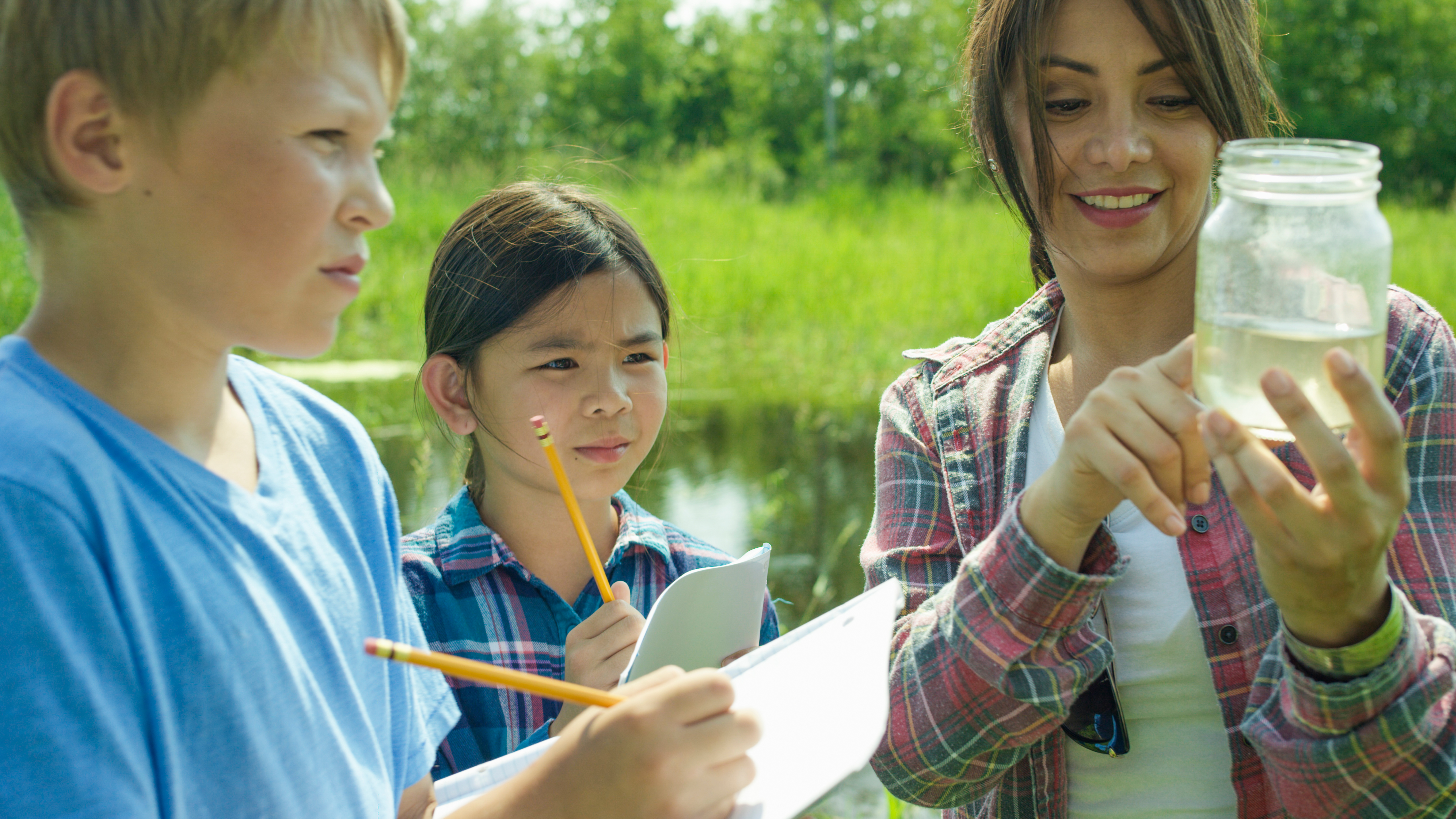 teacher and students examining water sample