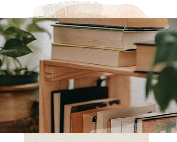 A book case with next to indoor plants