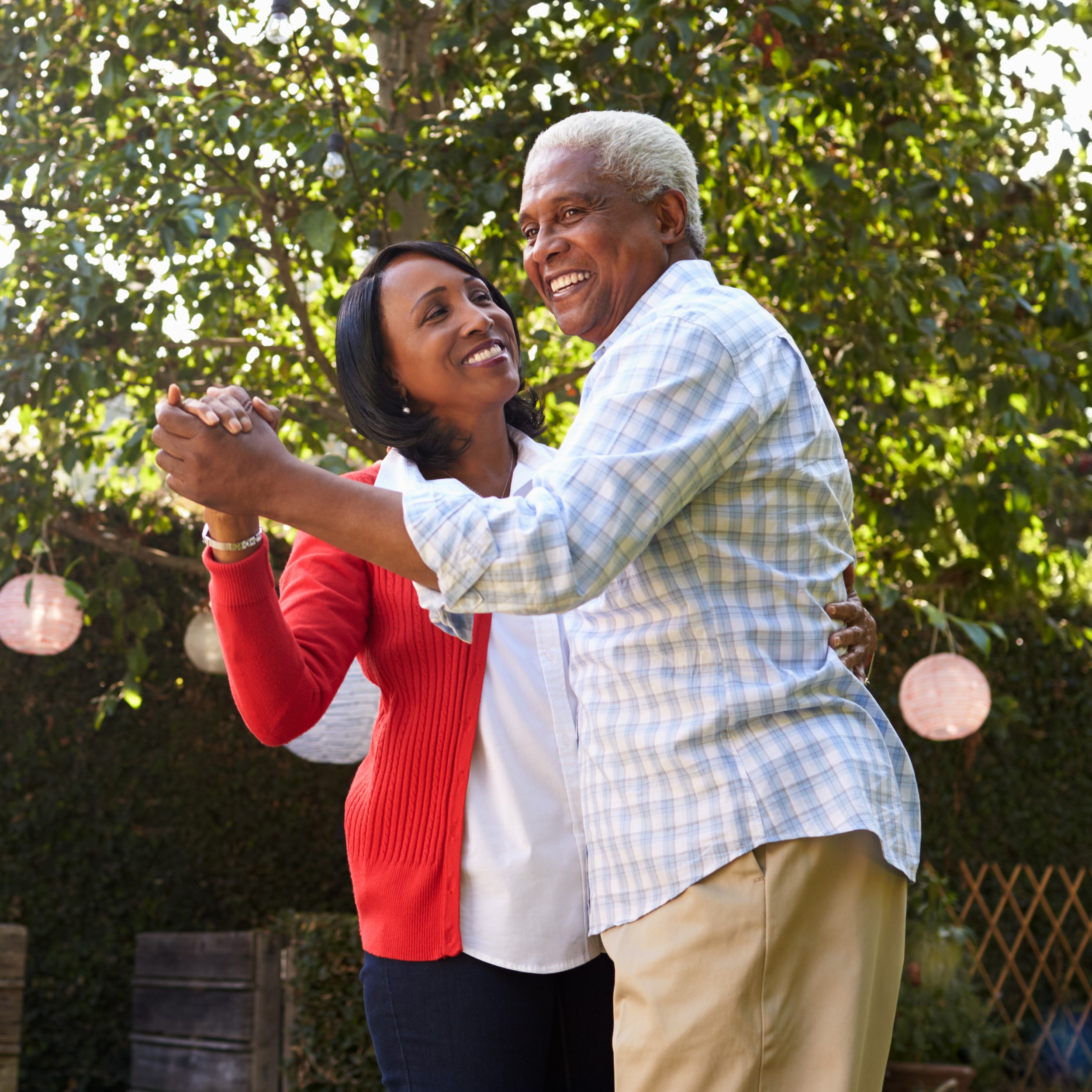 Retired couple dancing in a garden