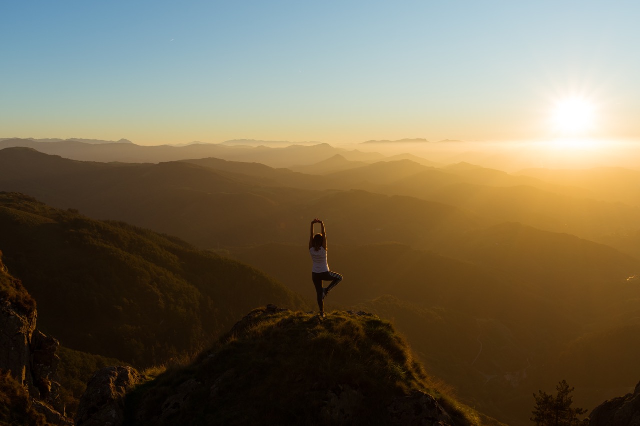 sun, tree pose on the top of a rock