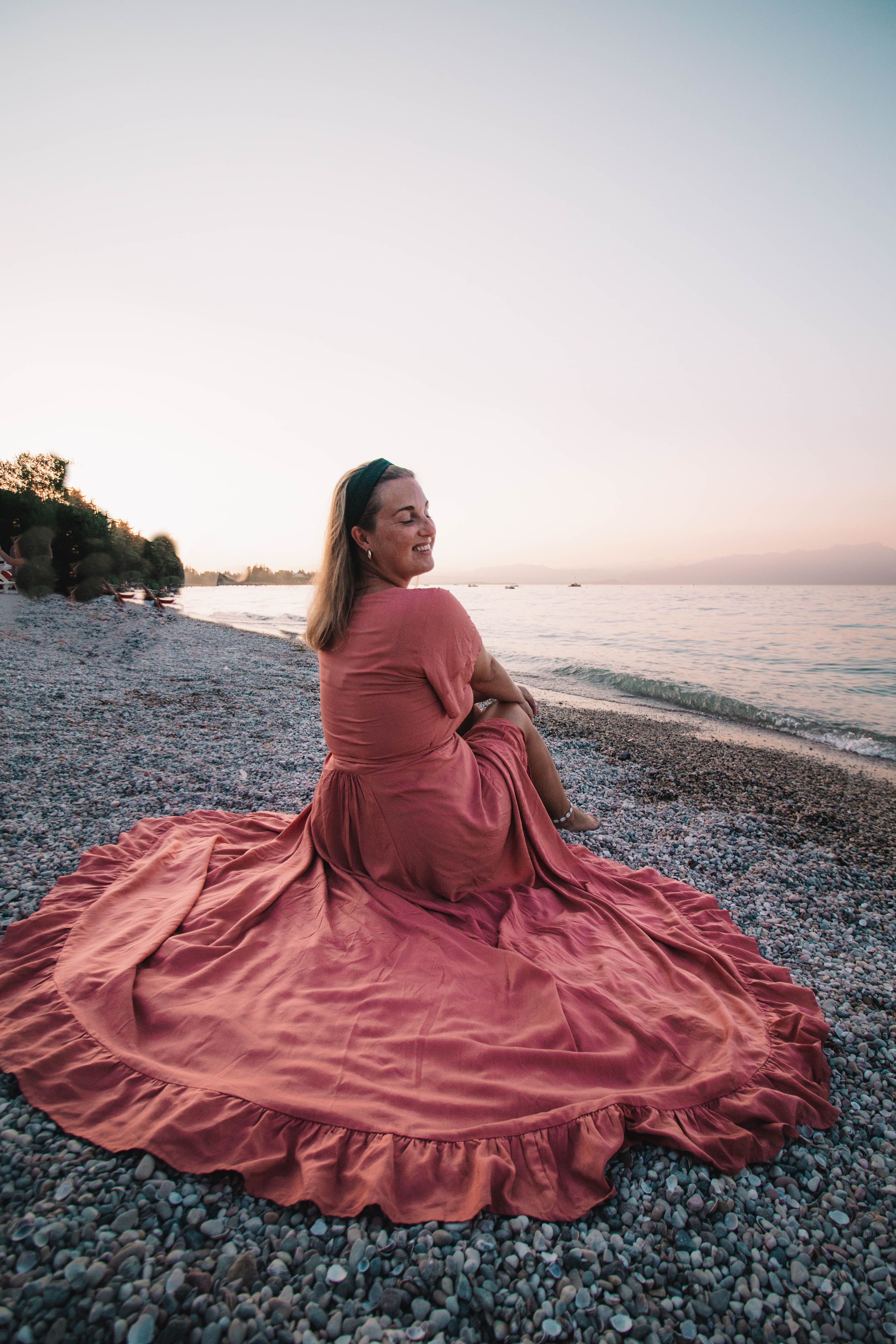 girl in pink flowy dress by the Garda Lake in Italy