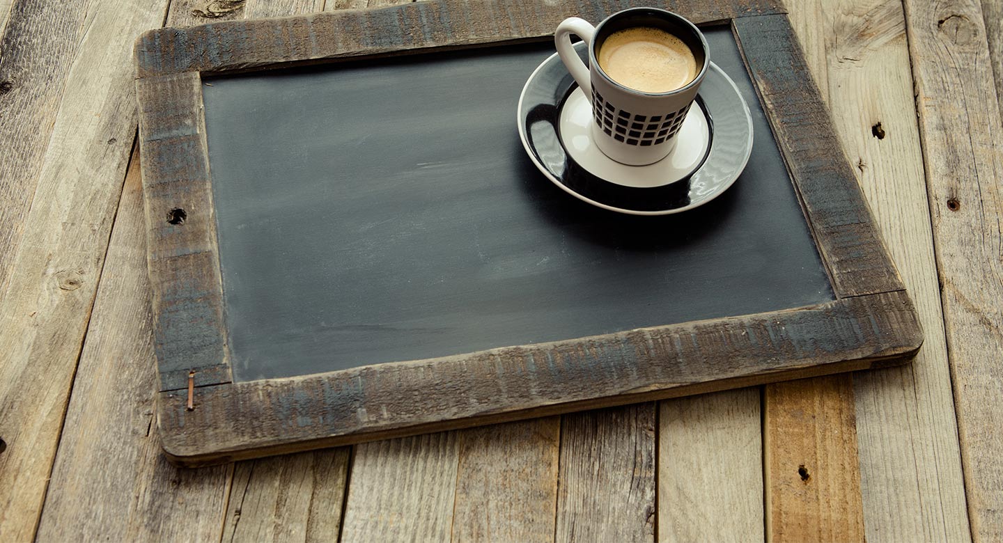 A chalkboard with a cup of coffee