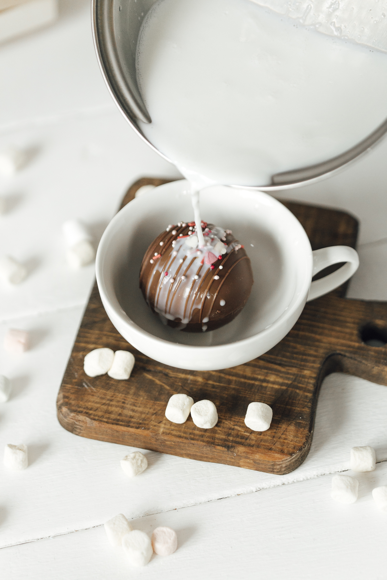 Image of warm milk being poured over hot chocolate cocoa bombs beside a description of how to increase sales of hot cocoa bombs in the food industry.