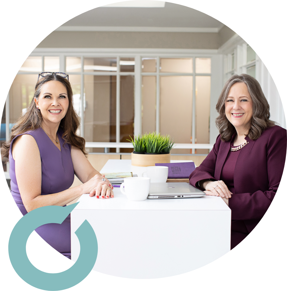 Marietta Stalcup and Heidi Thompson Sitting at a desk smiling