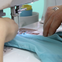 maquina de coser con manos y tela