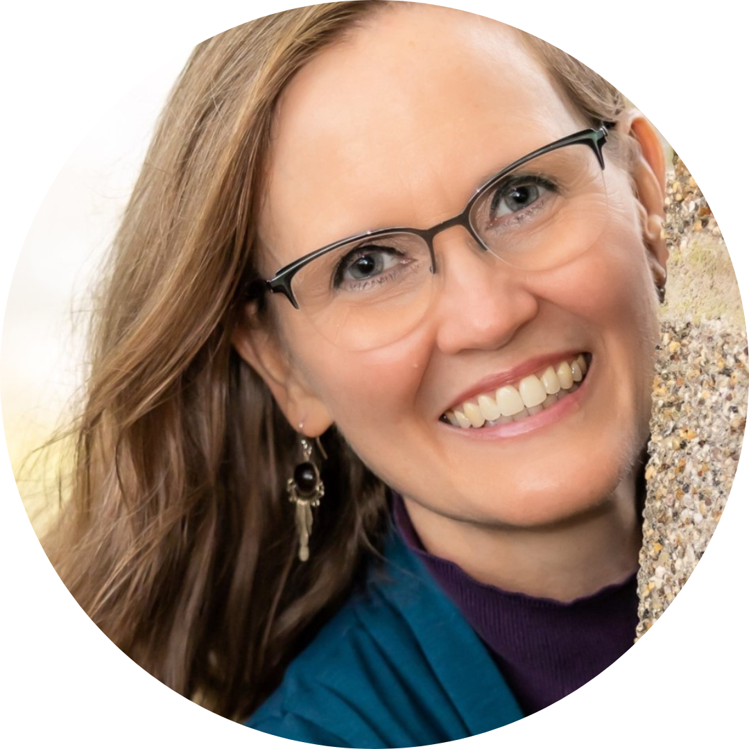 Dr Kristin Barnhart smiling next to cement wall