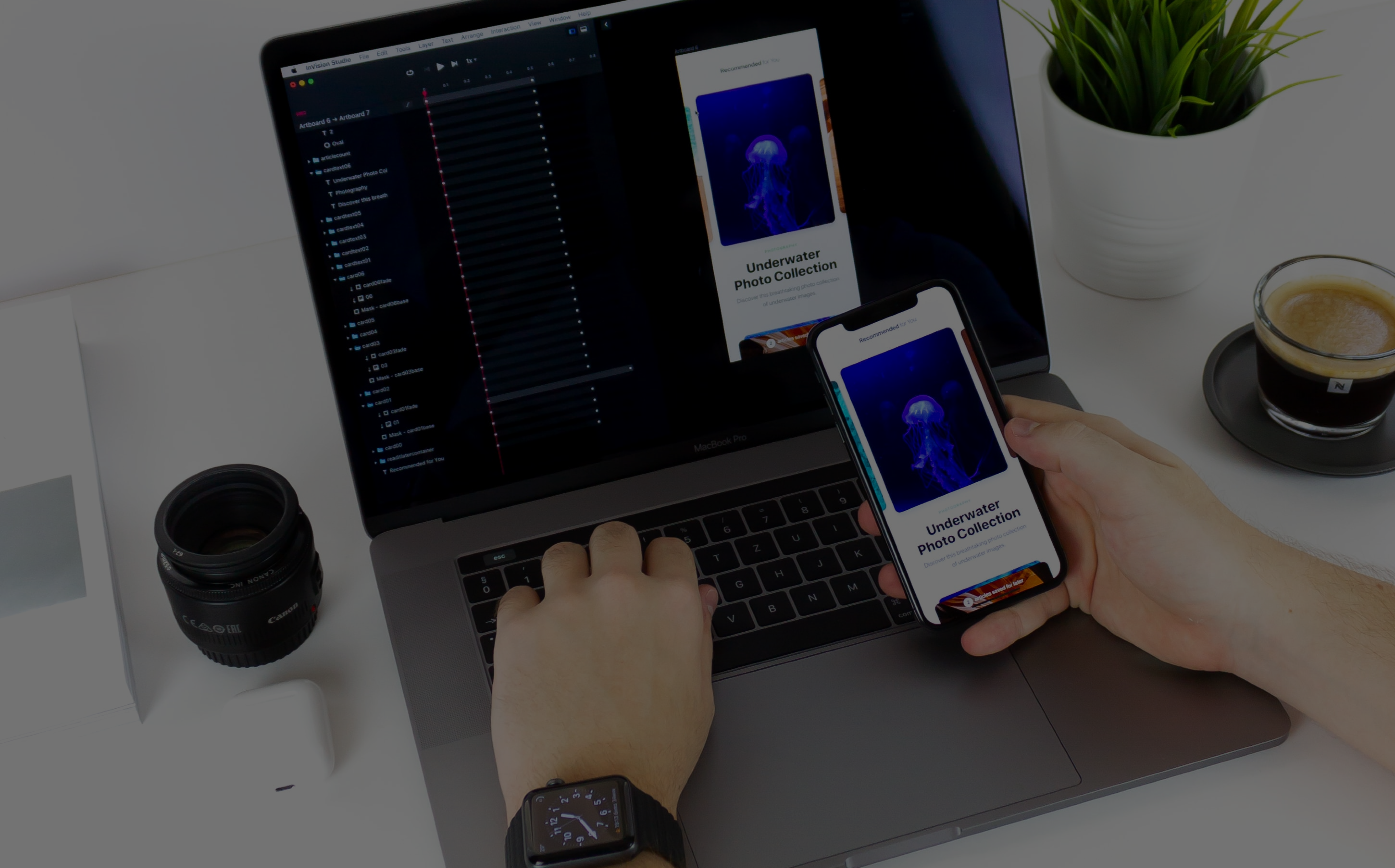 man holding iPhone next to laptop with design software running Figma 