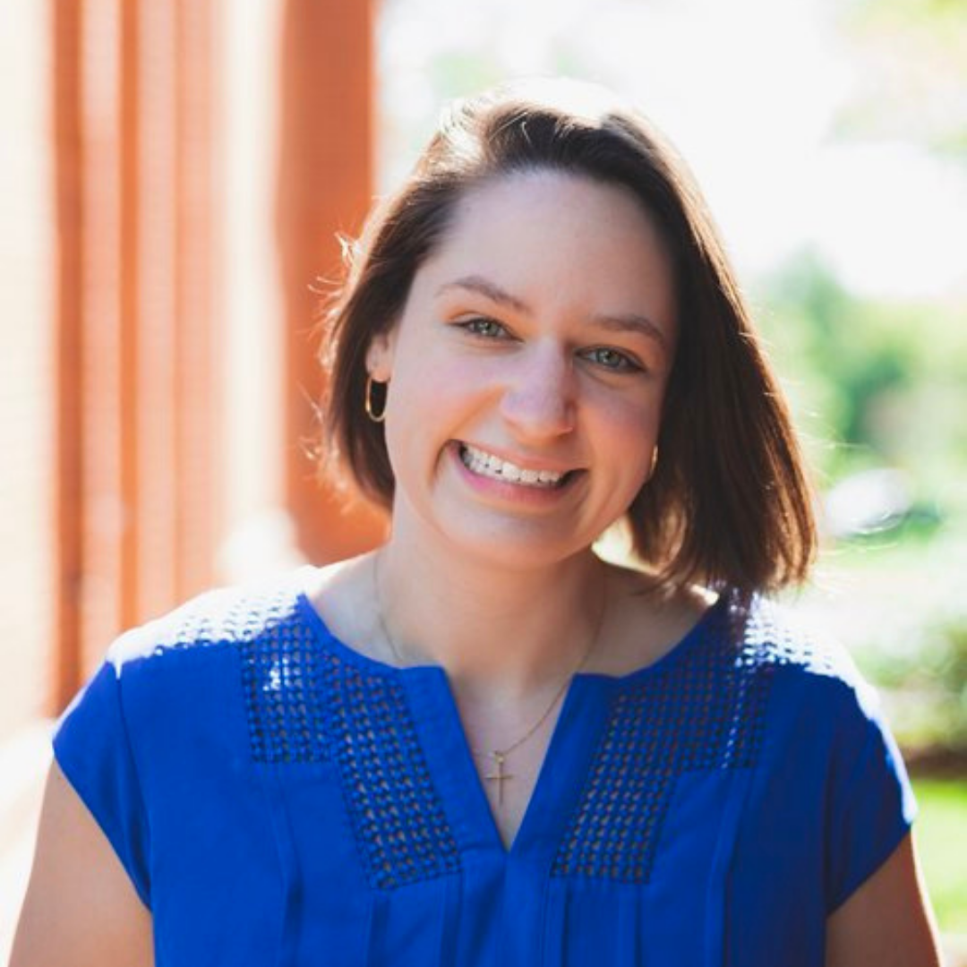 Sarah Bentley Allred in a blue shirt outside in front of a brick building