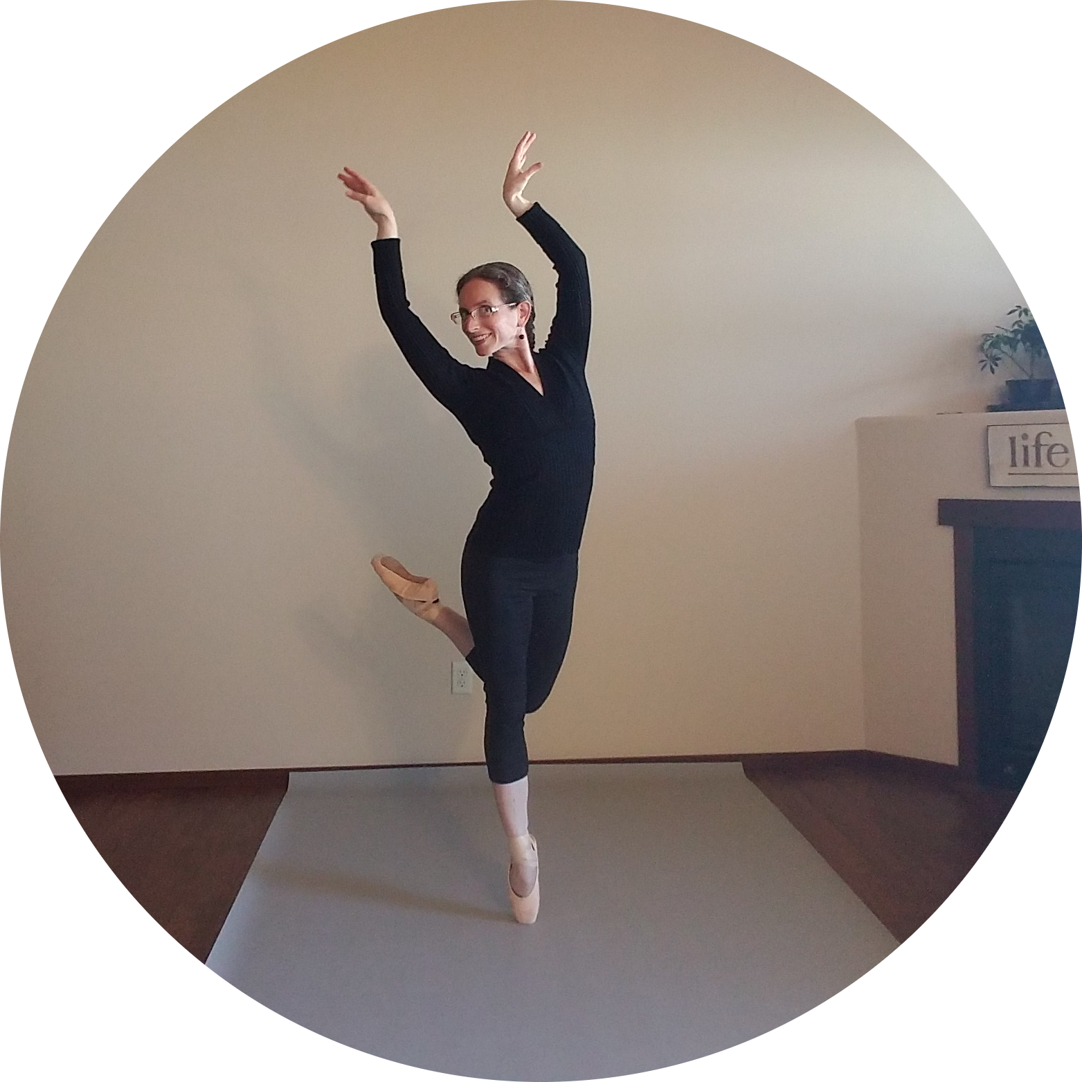 Instructor and Co-Founder Kate Feinberg Robins on one leg en pointe with other foot, hands, and gaze reaching to the left