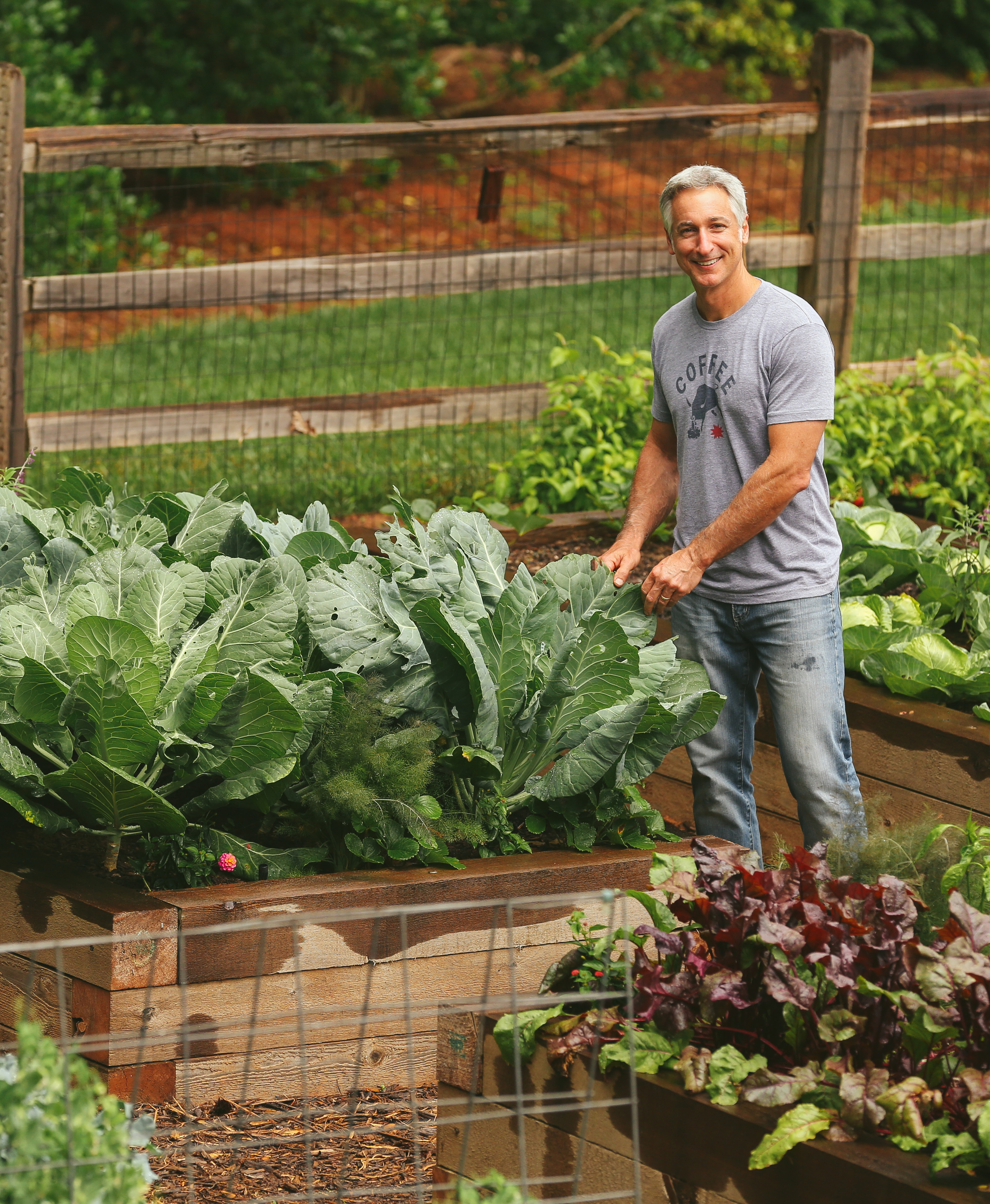 Joe in the garden touching leafy greens