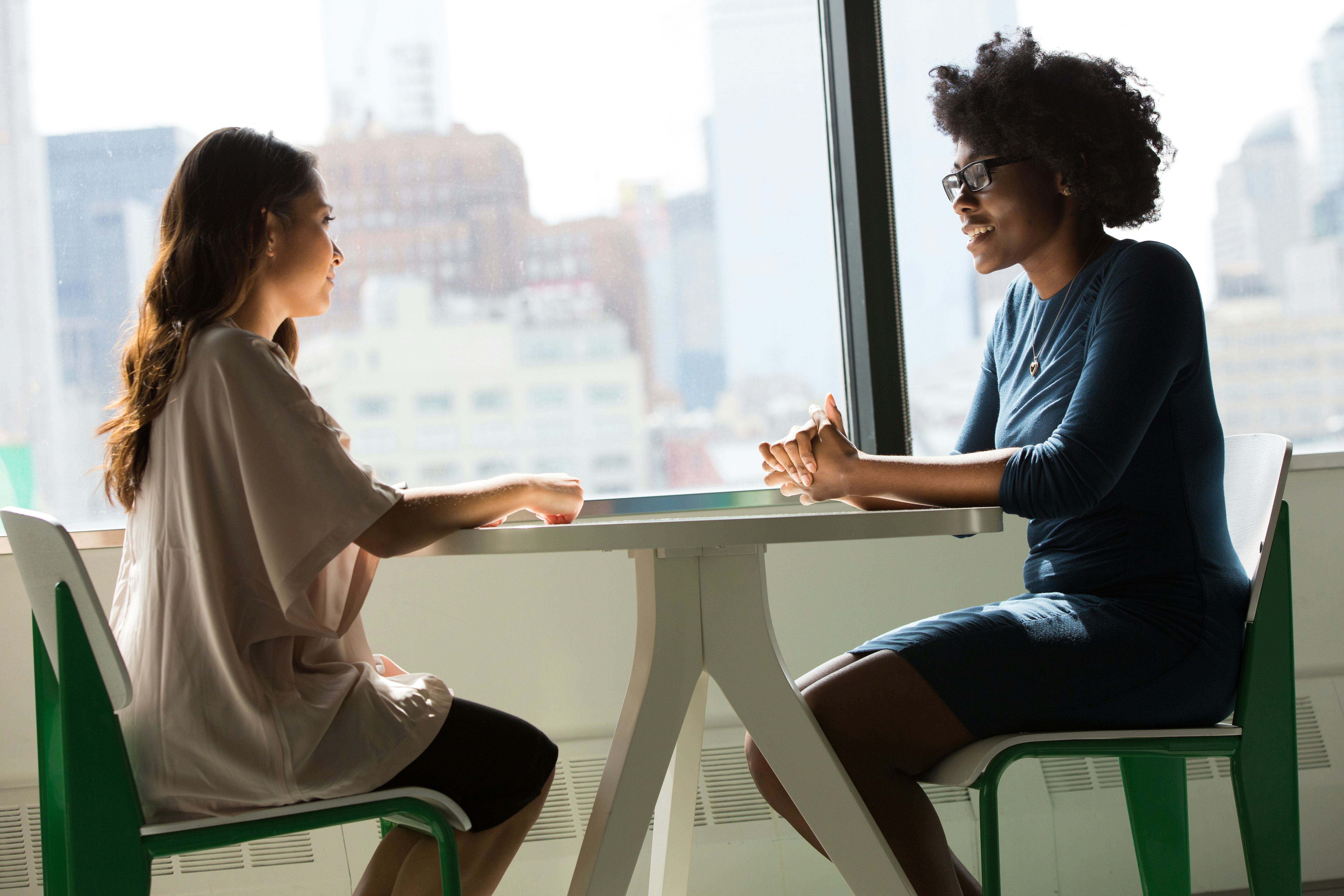 Two people sitting at round table talking