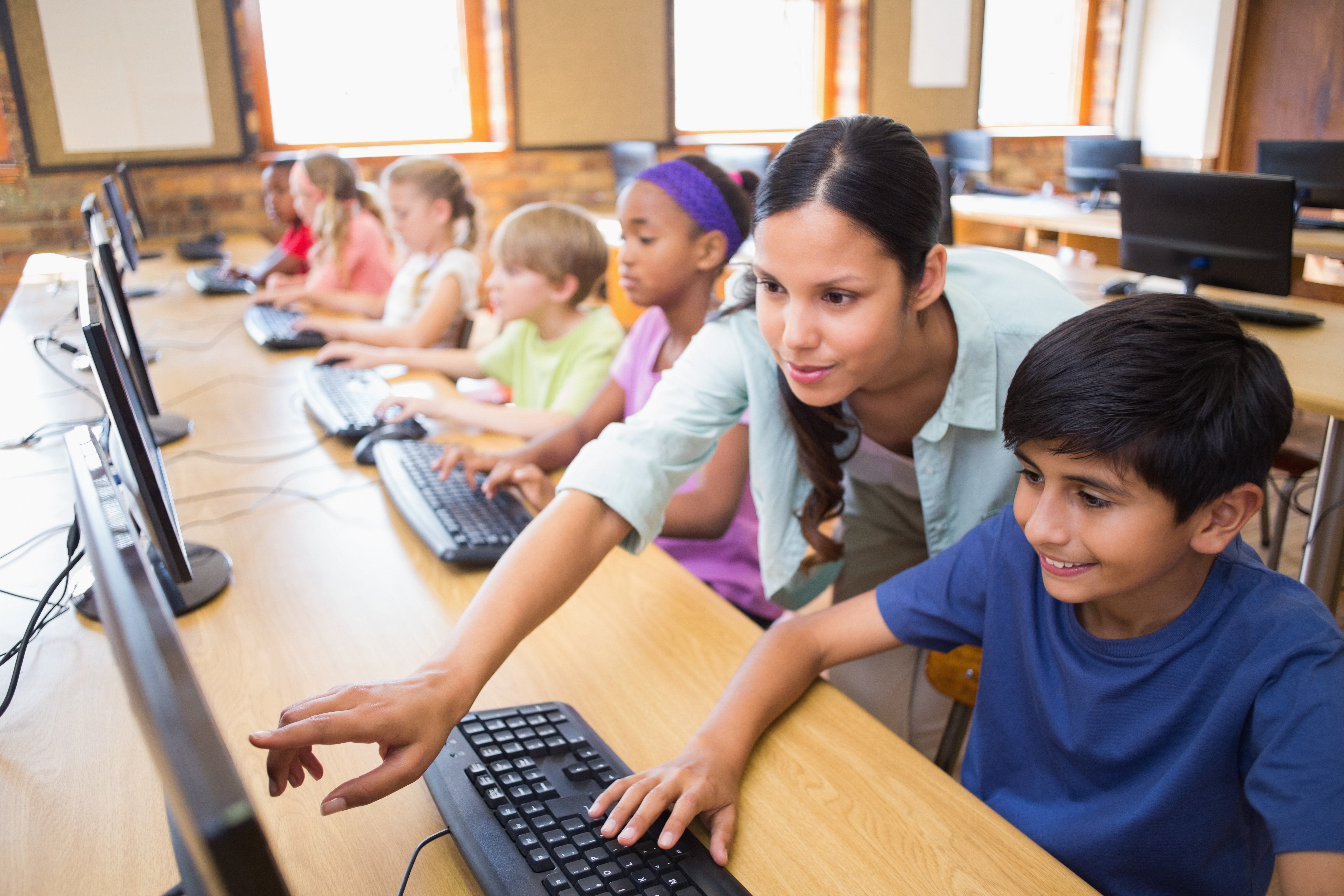 Teacher assisting students in the computer classroom